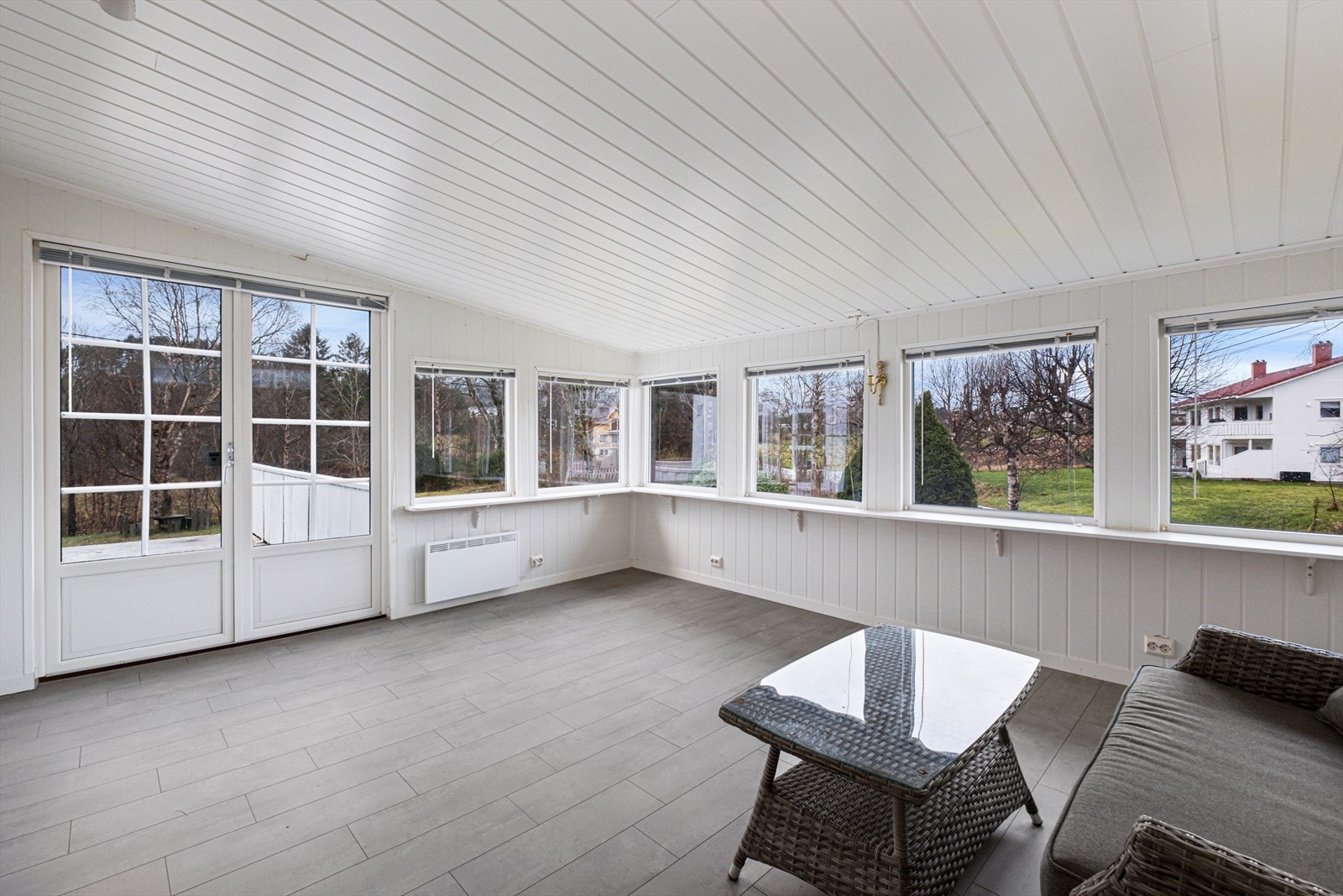 Store vinduer i utestuen gir godt med naturlig lys og utsikt mot hagen. Galleribilde