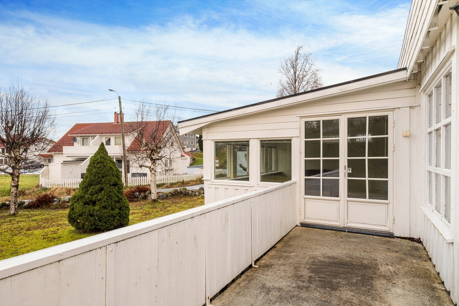 Dobbeldører gir tilgang til verandaen fra utestuen, med utsikt mot hagen. Galleribilde