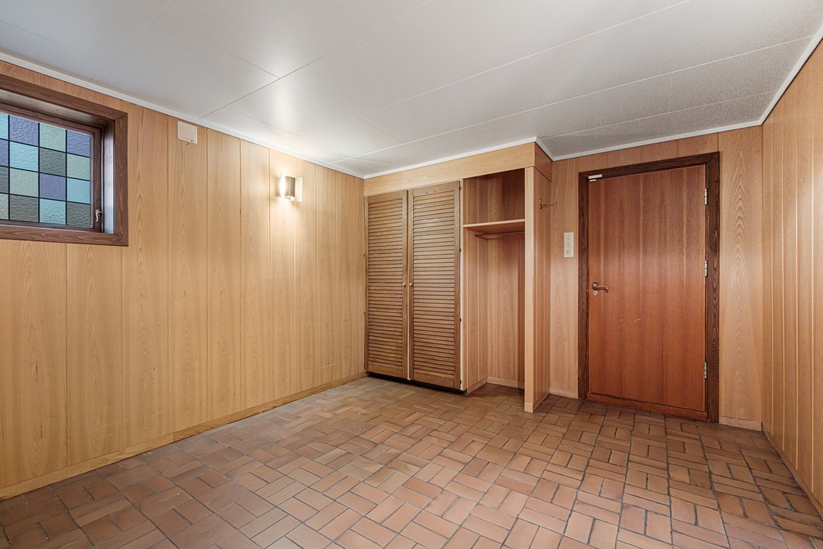 Skyvedørsgarderobe gir effektiv oppbevaring, og panelte vegger skaper et harmonisk uttrykk. Galleribilde