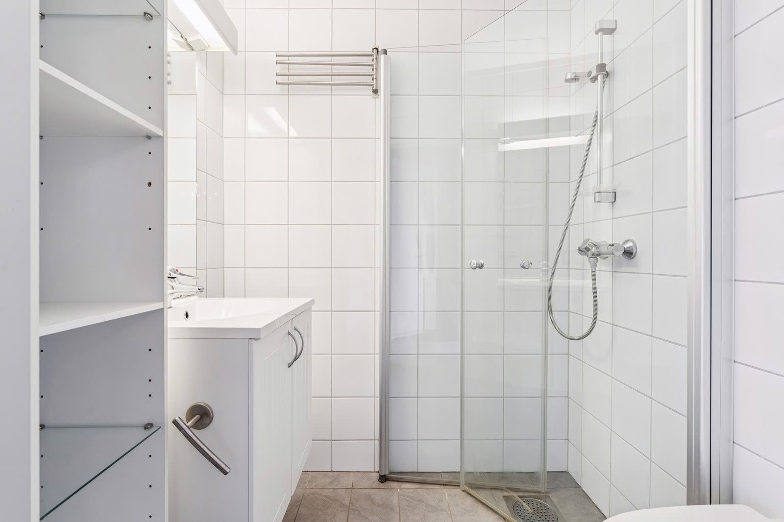 Flislagt med dusjhjørne, servant og toalett – praktisk for en stor husholdning. Galleribilde