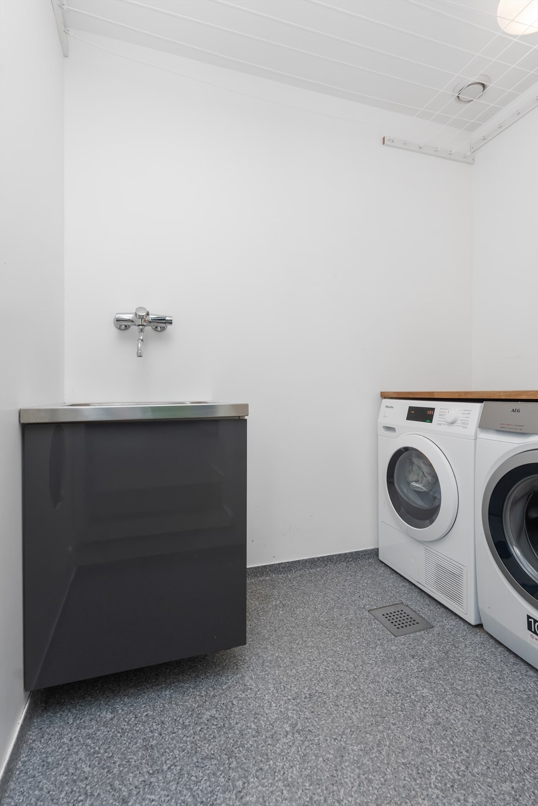 Som er praktisk utstyrt med vask og opplegg for vaskemaskin og tørketormmel, samt oppheng av klær. Galleribilde