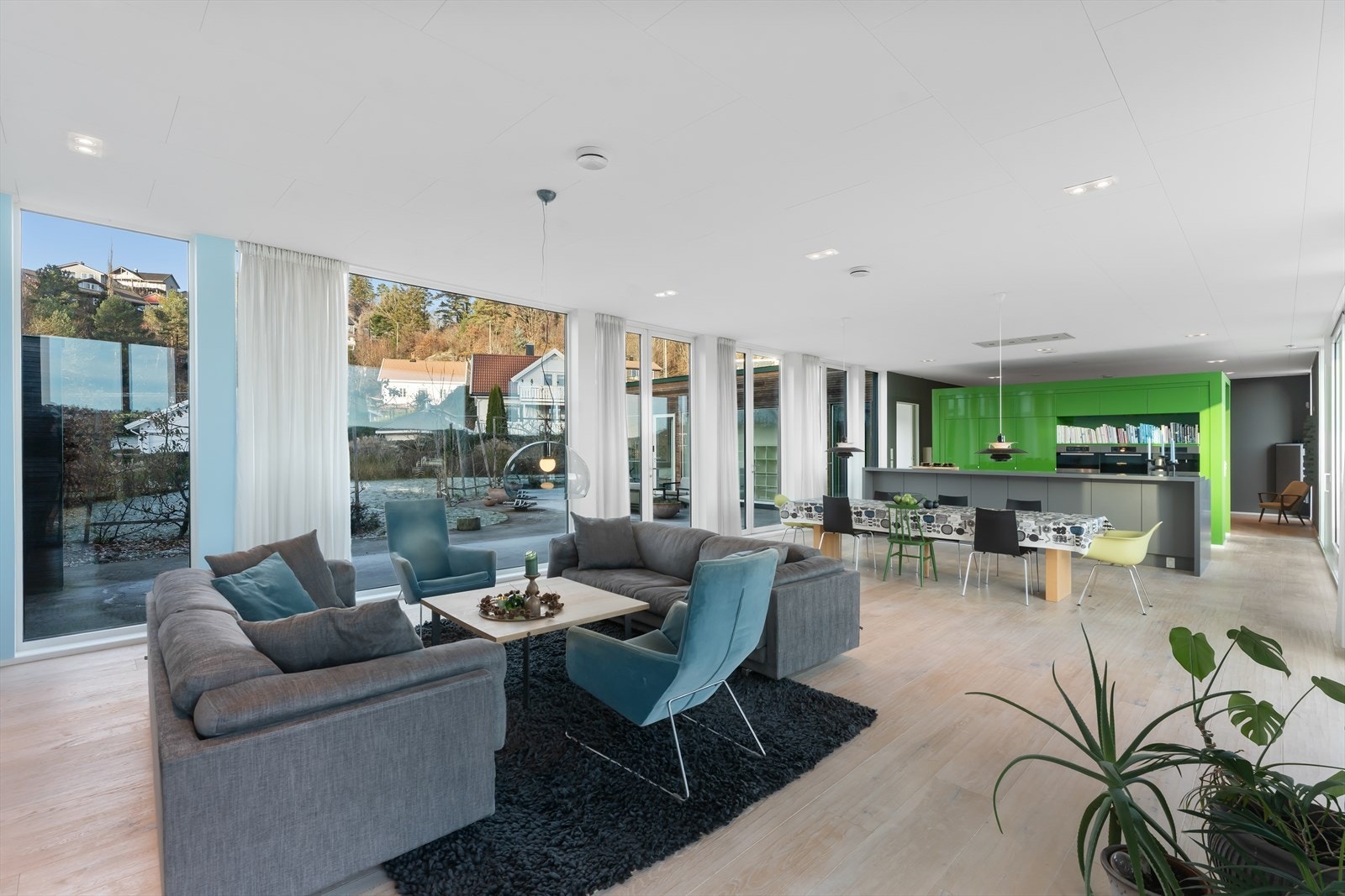 Inne finner vi store oppholdsrom og store vindusflater som strekker seg fra gulv til tak. (Det gjøres oppmerksom på at taklamper over spisebord og sofabord vil bli fjernet før overtagelse.) Galleribilde