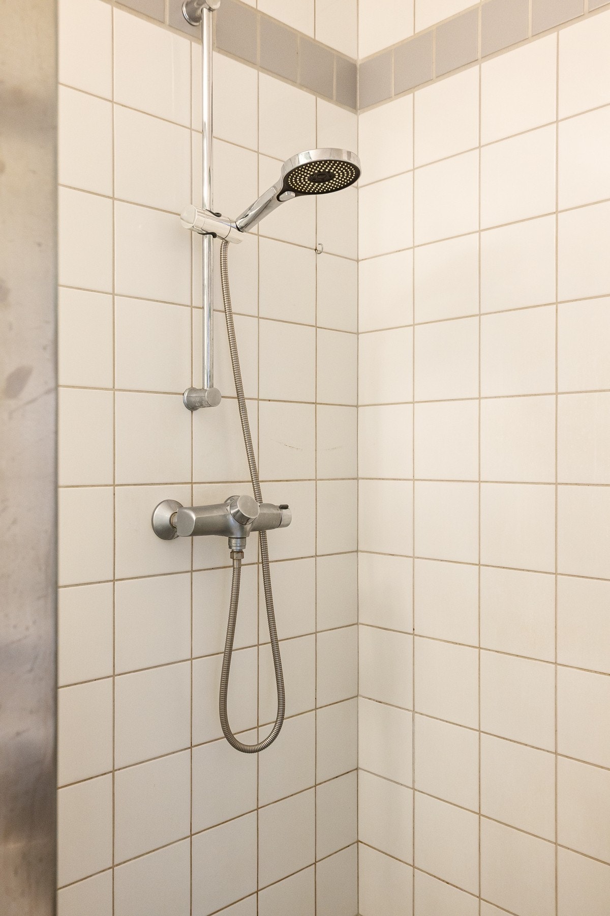 Dusjløsningen er plassert i hjørnet med murt glassbetong som dusjvegge og har både hånd- og regnfallsdusj. Galleribilde