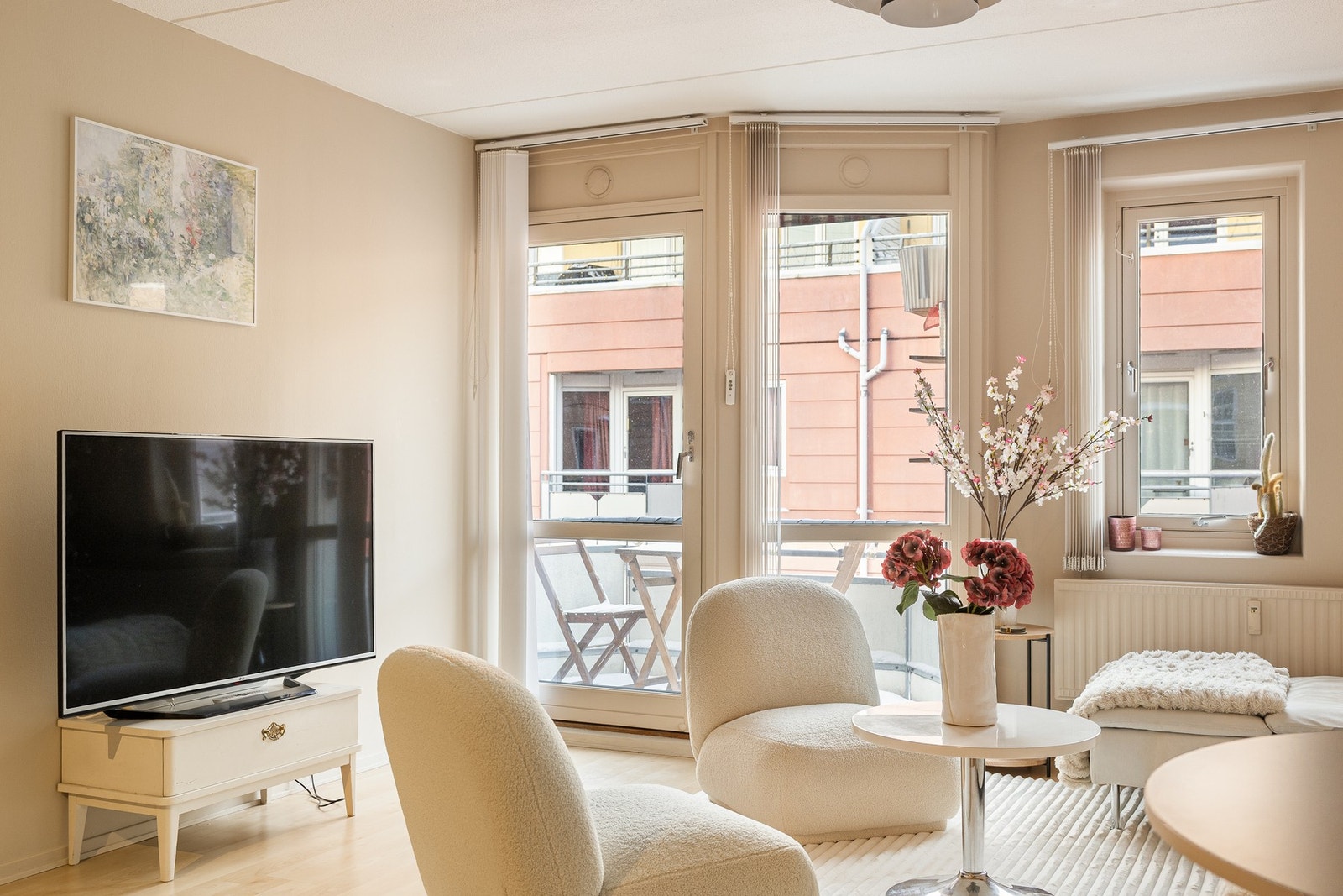 Romslig stue byr på store vinduer som sikrer rikelig med naturlig lys og varme fra radiatorer under vinduet. Galleribilde