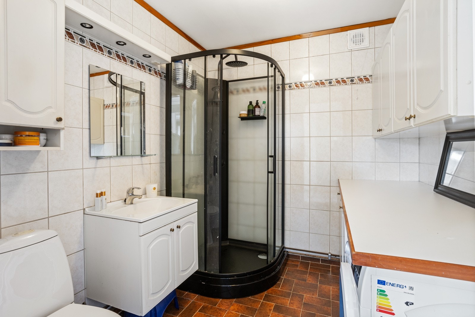 Flislagt bad med gulvvarme. Sanitærutstyr bestående av toalett, servant med underskap, nytt dusjkabinett og røropplegg til vaskemaskin Galleribilde