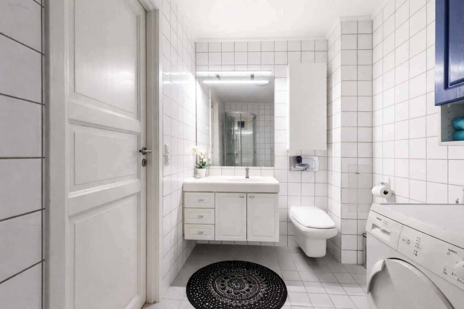 Boligen har to bad, praktisk plassert med ett i hver etasje. Badet i første etasje er fra byggeår og har hvite fliser på gulv og vegger samt gulvvarme. Galleribilde