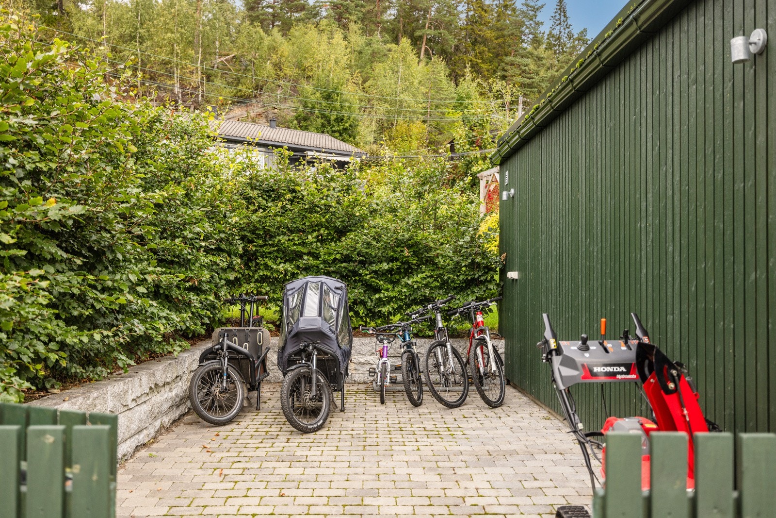 Bak garasjen er det felles oppstillingsplass til sykler, snørfreser osv. Galleribilde