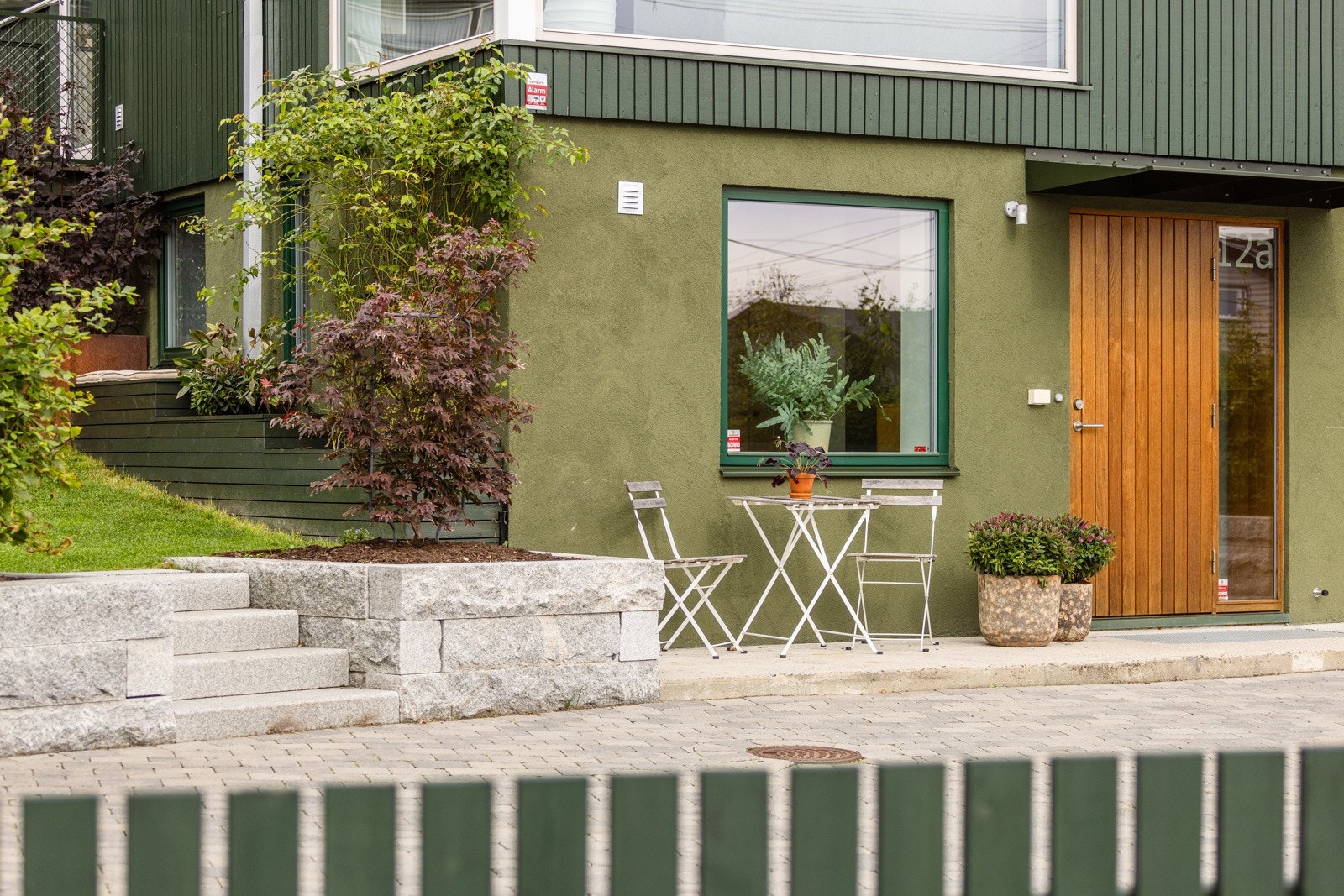 Pent opparbeidet uteplass ved inngangdøren. Det er lagt belegningsstein på felles uteplass. Galleribilde