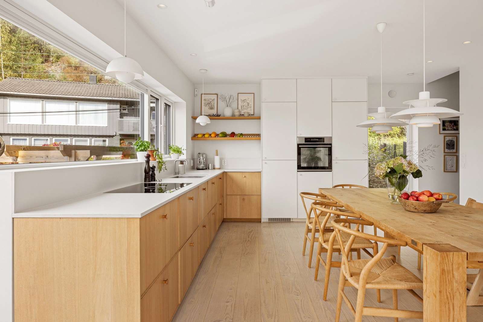 Store vindusflater åpner opp og slipper lyset inn. Det er også fint å se barna leke i hagen mens man lager mat. Galleribilde