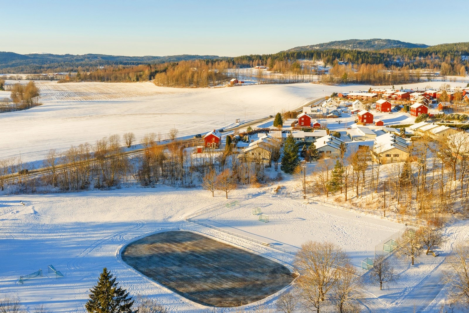 Dronebilde mot vest. Boligen ligger med kort gangavstand til Fossum IL. med Fotball, langrenn, skiskyting, hopp, orientering mm. Galleribilde
