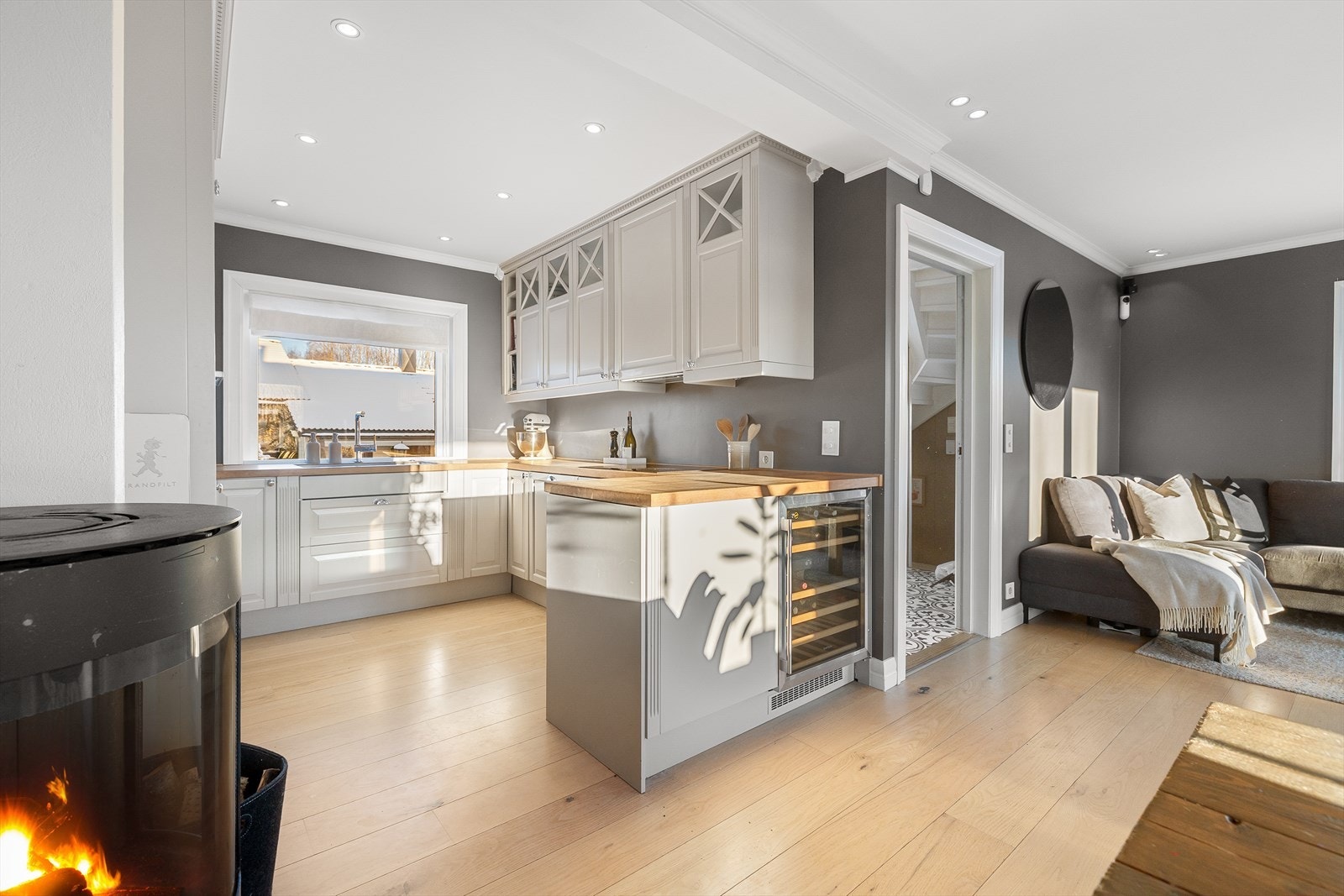 Pent innredning med hvite, profilerte fronter, enkelte overskapfronter har innfelt glassfelt og heltre benkeplate. Galleribilde