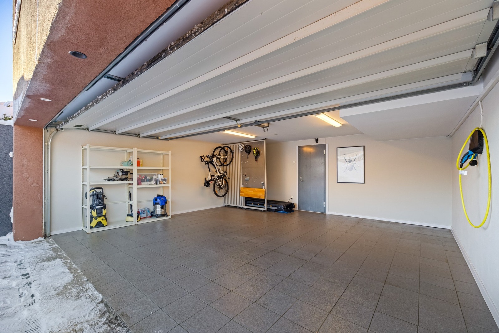 Romslig dobbelgarasje med elbillader og elektrisk garasjeport. Galleribilde