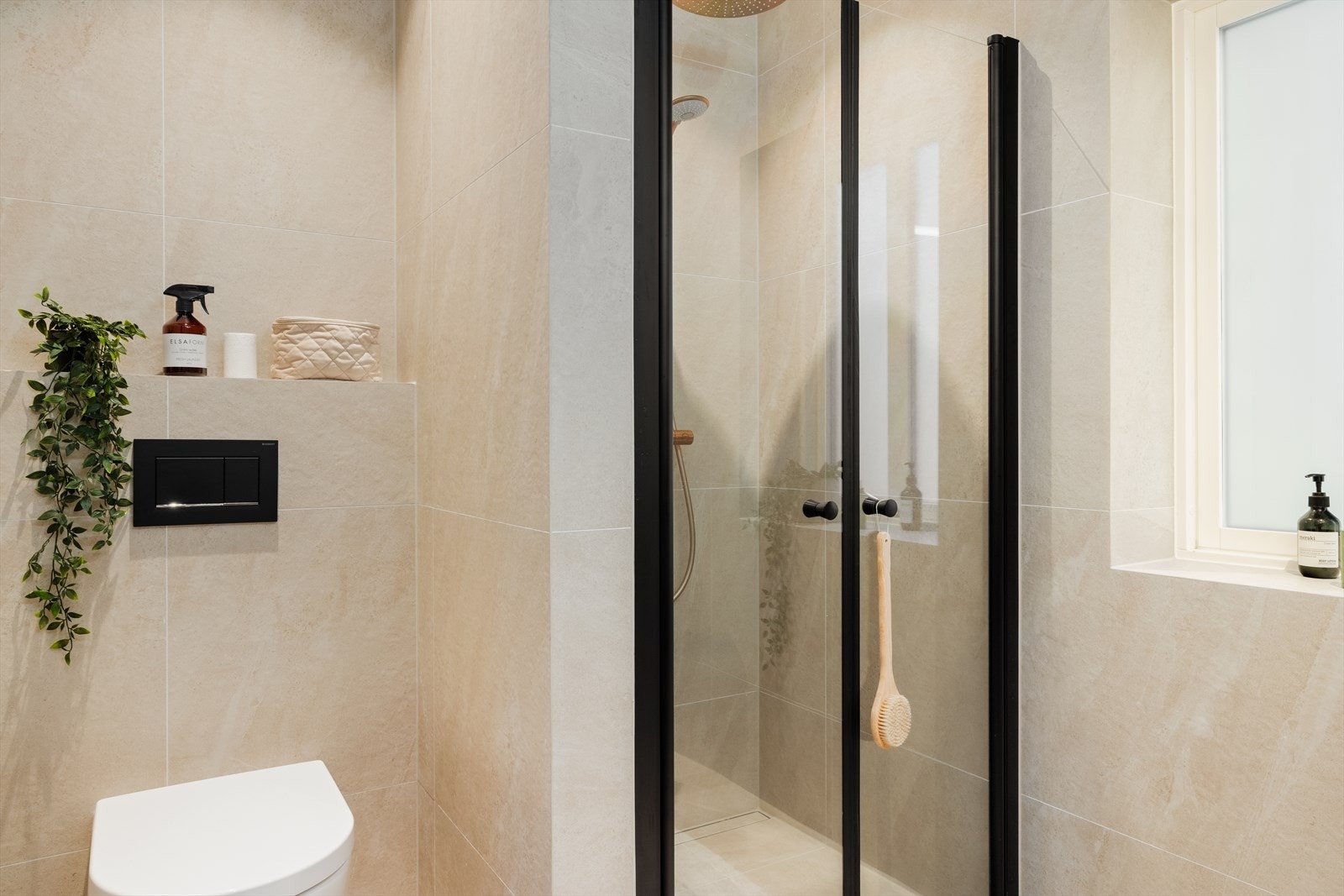 Badet har moderne innredning med design møbler fra INR, veggmontert toalett samt dusj i hjørne, og fremstår som både funksjonelt og stilrent. Galleribilde