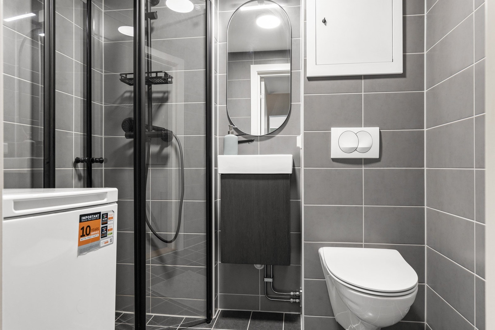 Innredningen består av vegghengt servantskap med ovenpåliggende servant, vegghengt toalett, dusjhjørne med innfellbare glassdører og speil med belysning og stikkontakter på vegg. Opplegg for vaskemaskin. Galleribilde