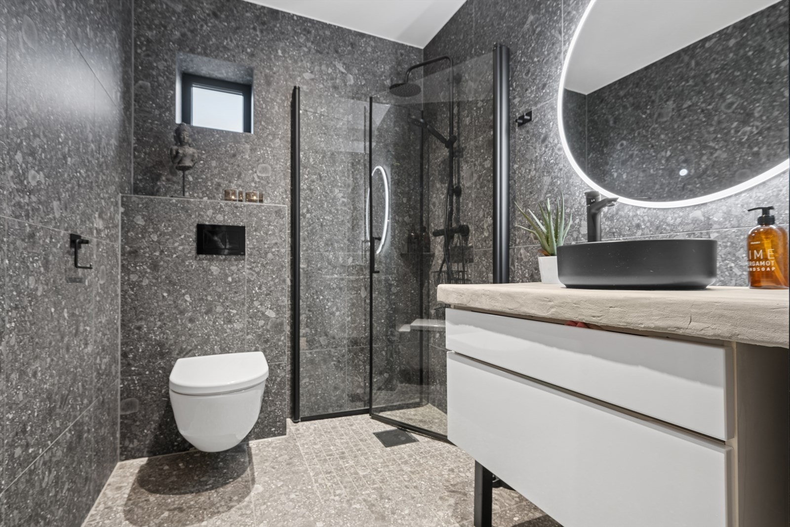 Baderom 2 i 1.etg. Flislagt og med nedfelt servant, veggmontert toalett og dusjvegger/hjørne. Galleribilde