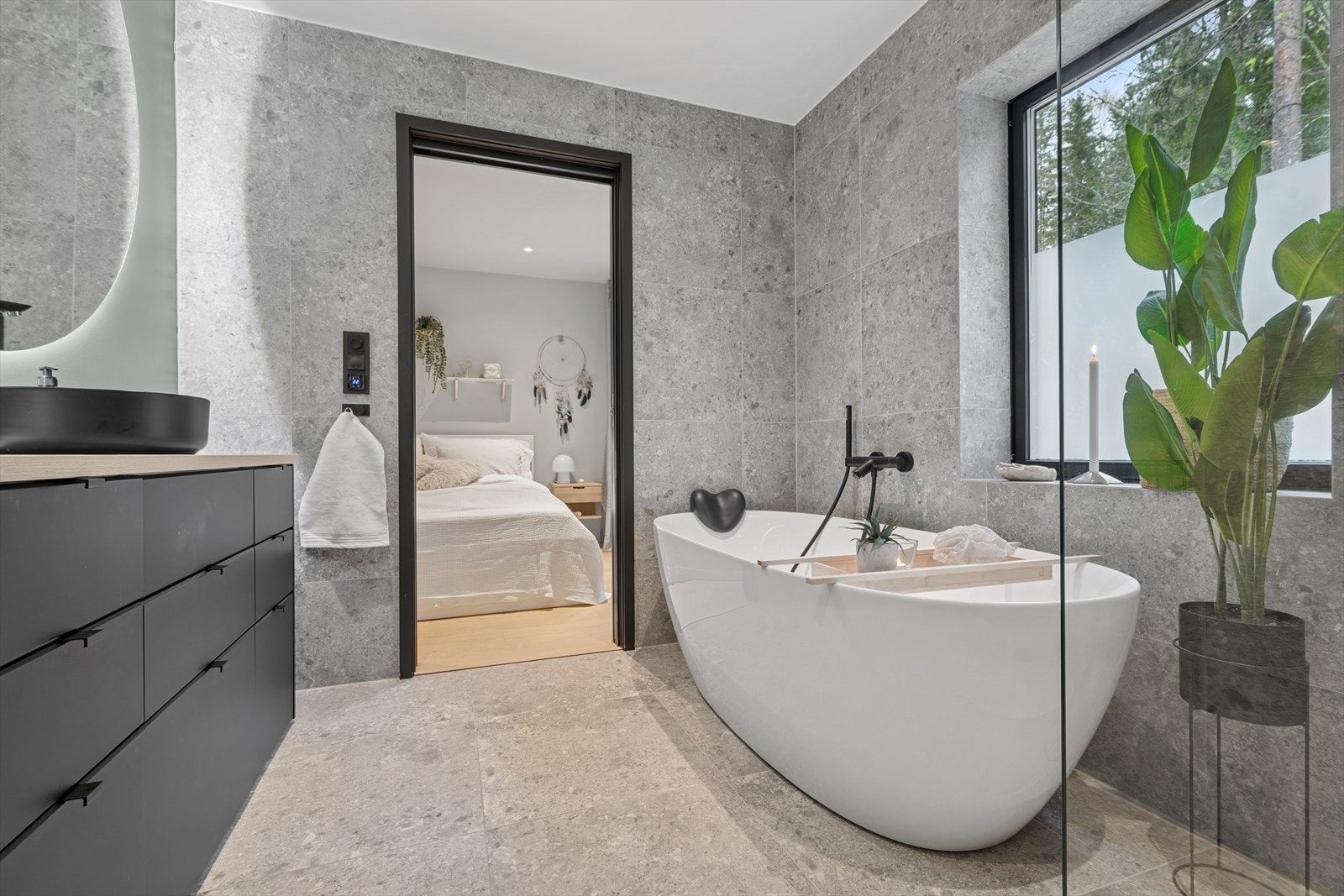 Badet har innredning med servant, veggmontert toalett, badekar og dusjvegger. Galleribilde