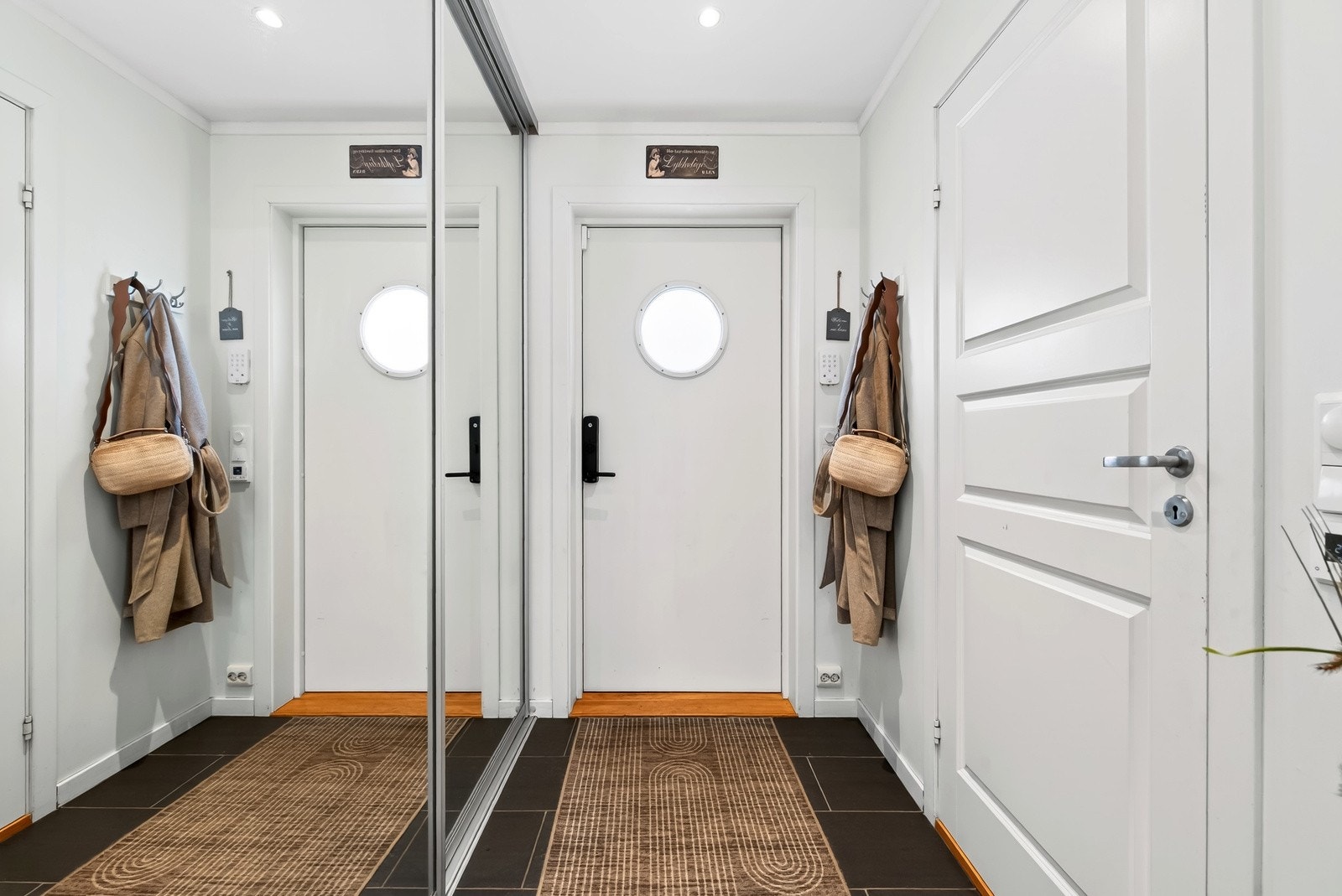 Lys og fin gang hvor det er oppbevaring av ytterklær og sko i skyvedørsgarderobe med speildører for et ryddig uttrykk. Galleribilde