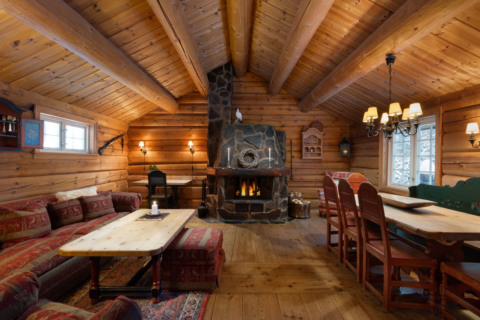 Hyttens hjerte er den åpne stuen/spisestuen, med den lekre peisen som midtpunkt Galleribilde