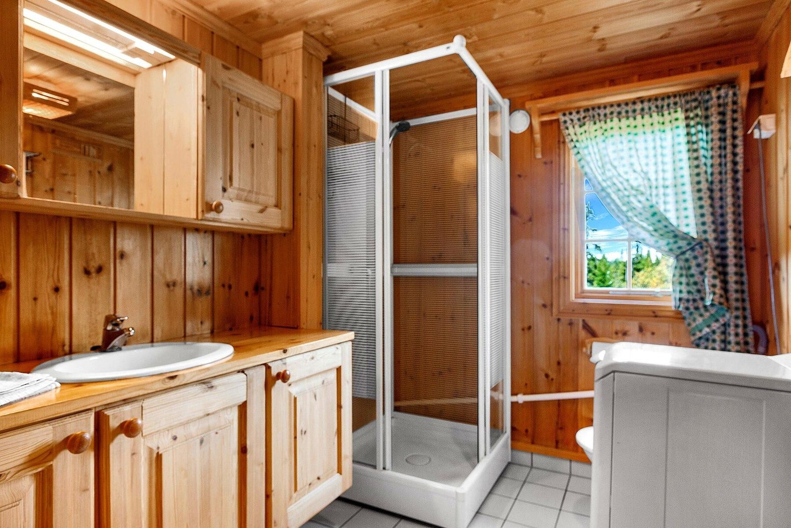 Bad med flislagt gulv med varme. Montert toalett og dusjkabinett. Opplegg for vaskemaskin. Galleribilde