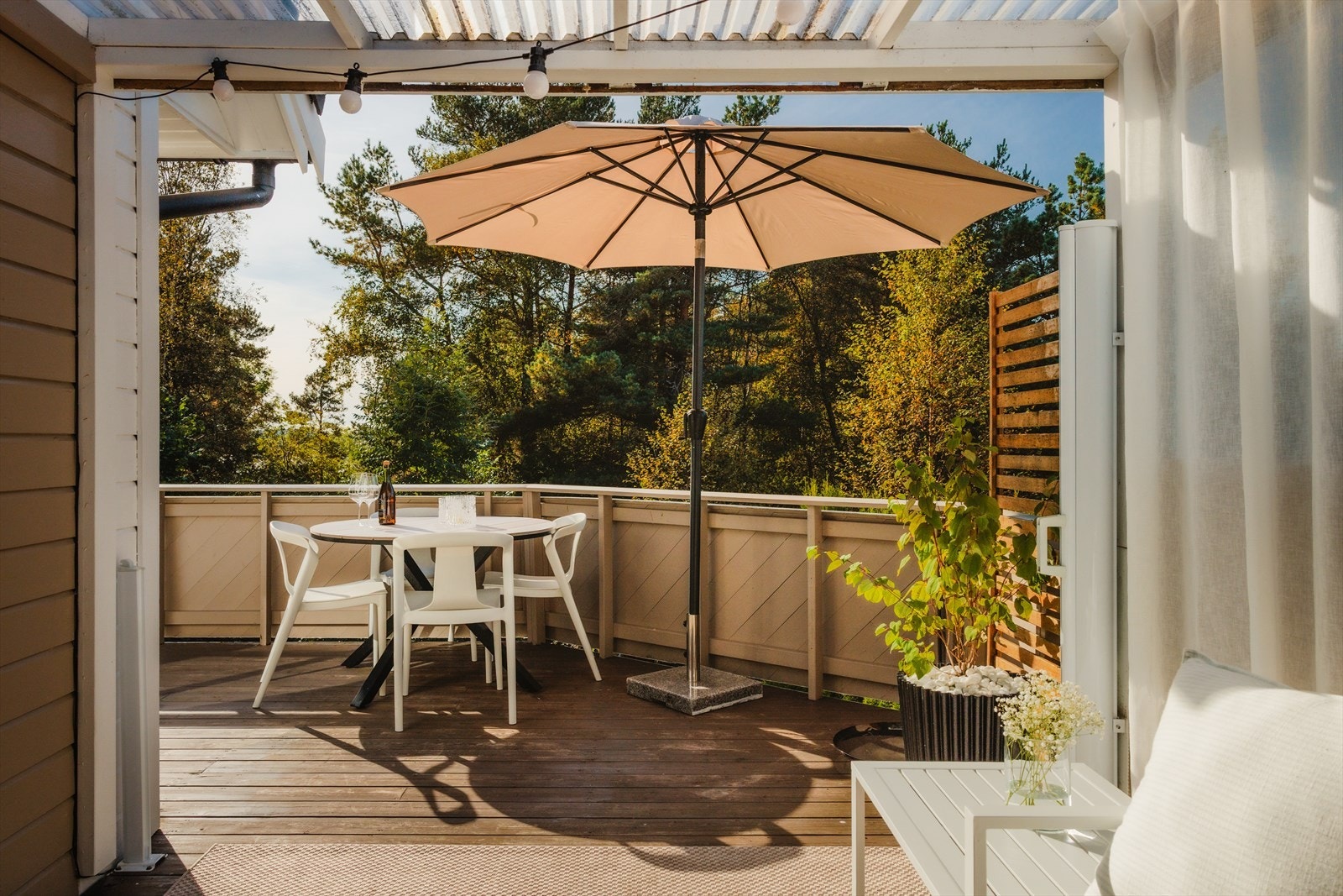 Altanen fungerer som et naturlig uterom i sommerhalvåret og gir en herlig forlengelse av stuen, perfekt for både avslapning og sosiale stunder Galleribilde