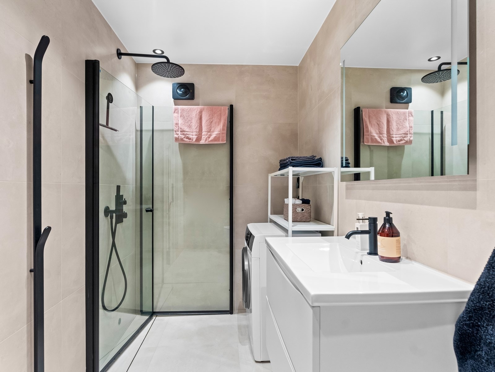 Badet er også bygd nytt i 2024. Gulv og vegger er flislagte. Rommet er innredet med dusj på gulv med dører i herdet glass, veggfestet klosett med innebygget sisterne, opplegg for vaskemaskin og servant. Galleribilde