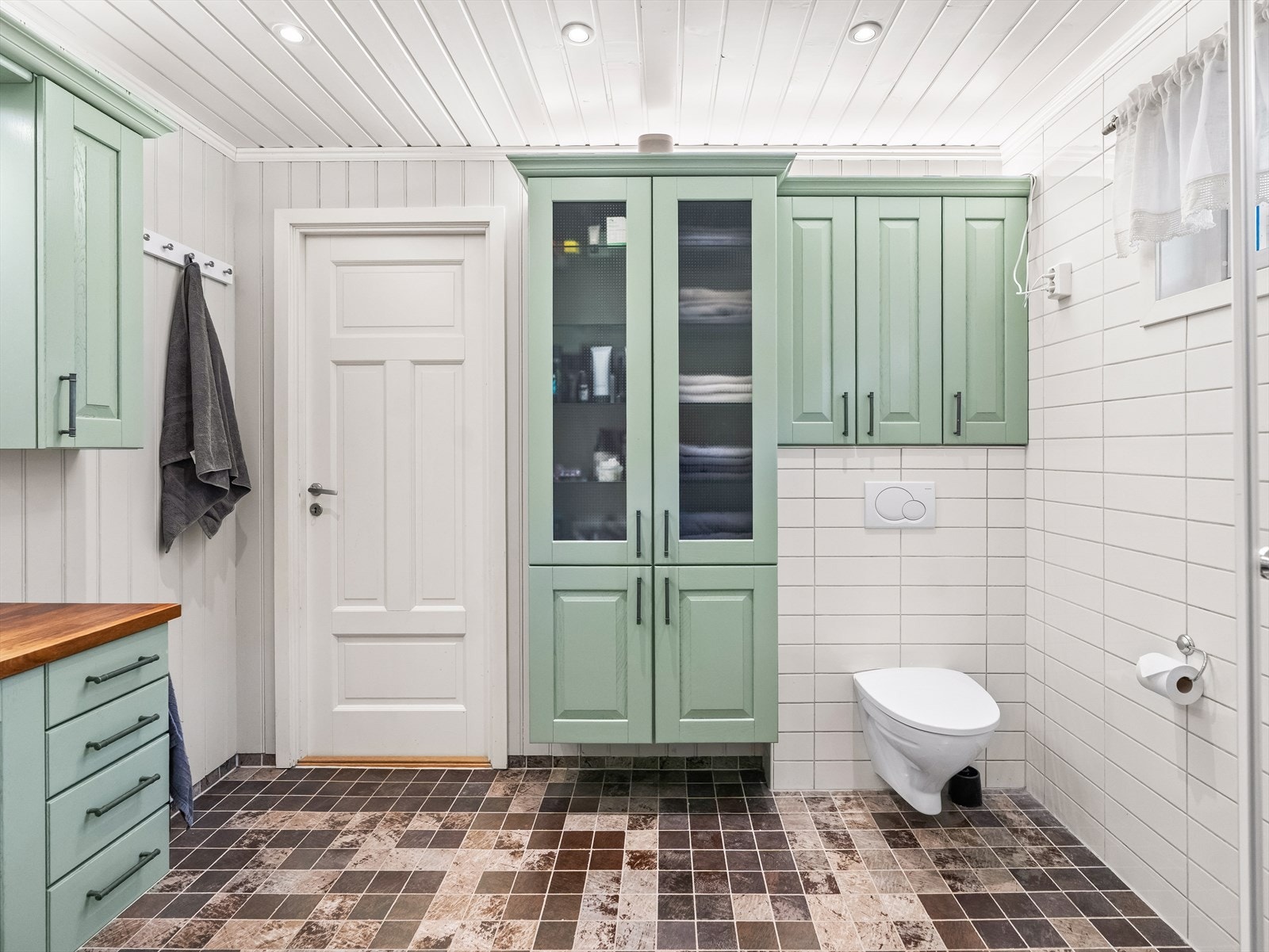 Ved servanten er det montert benkeskap og veggskap med profilerte fronter. Galleribilde