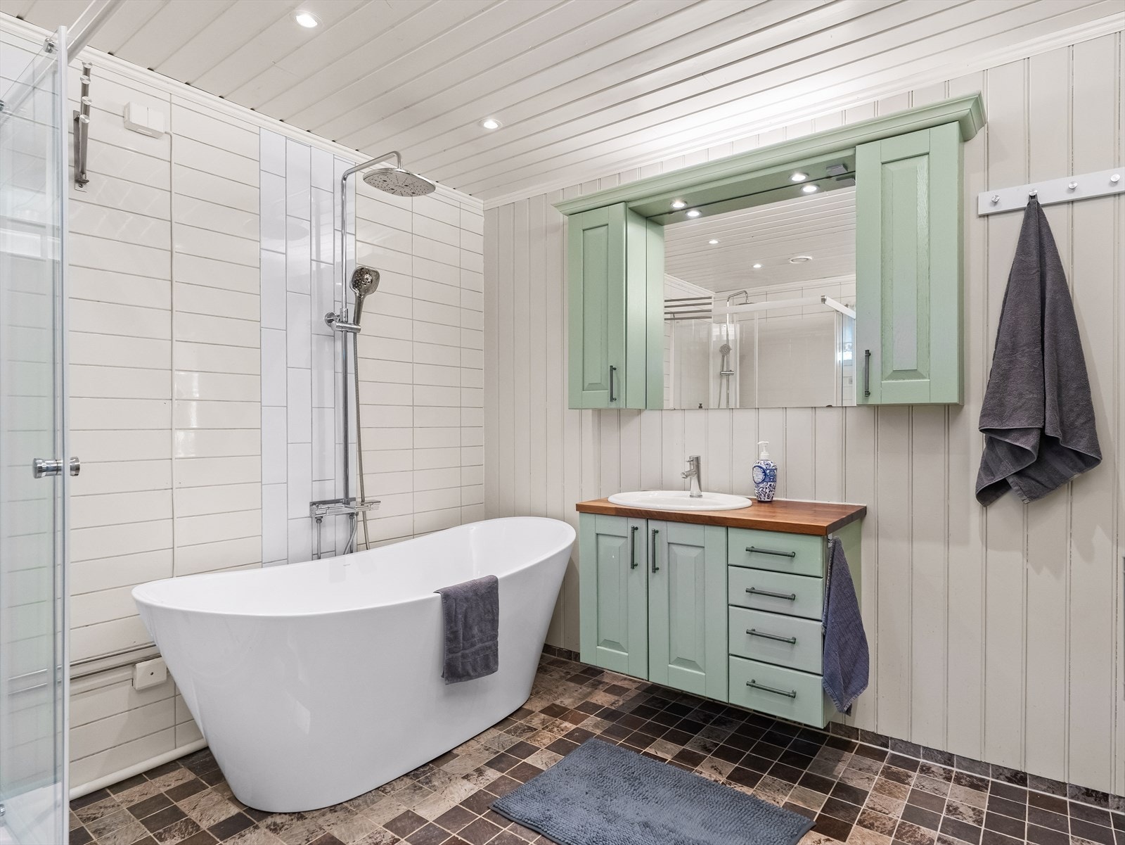 Rommet er utstyrt med dusjkabinett, badekar, veggfestet klosett med innebygget sisterne samt servant. Galleribilde