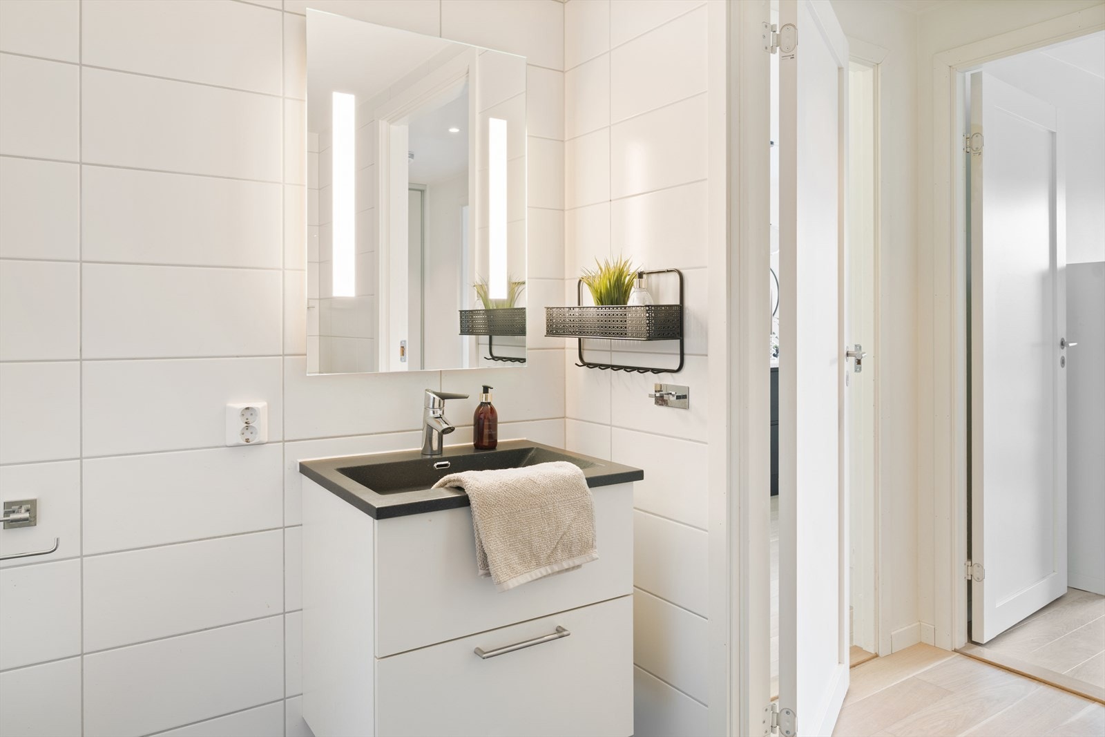 Helfliset bad med dusjhjørne og veggmontert toalett. Galleribilde