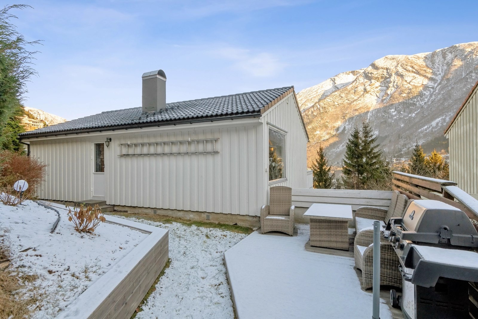 På baksiden av boligen er det en pent opparbeidet hage med treplatting Galleribilde