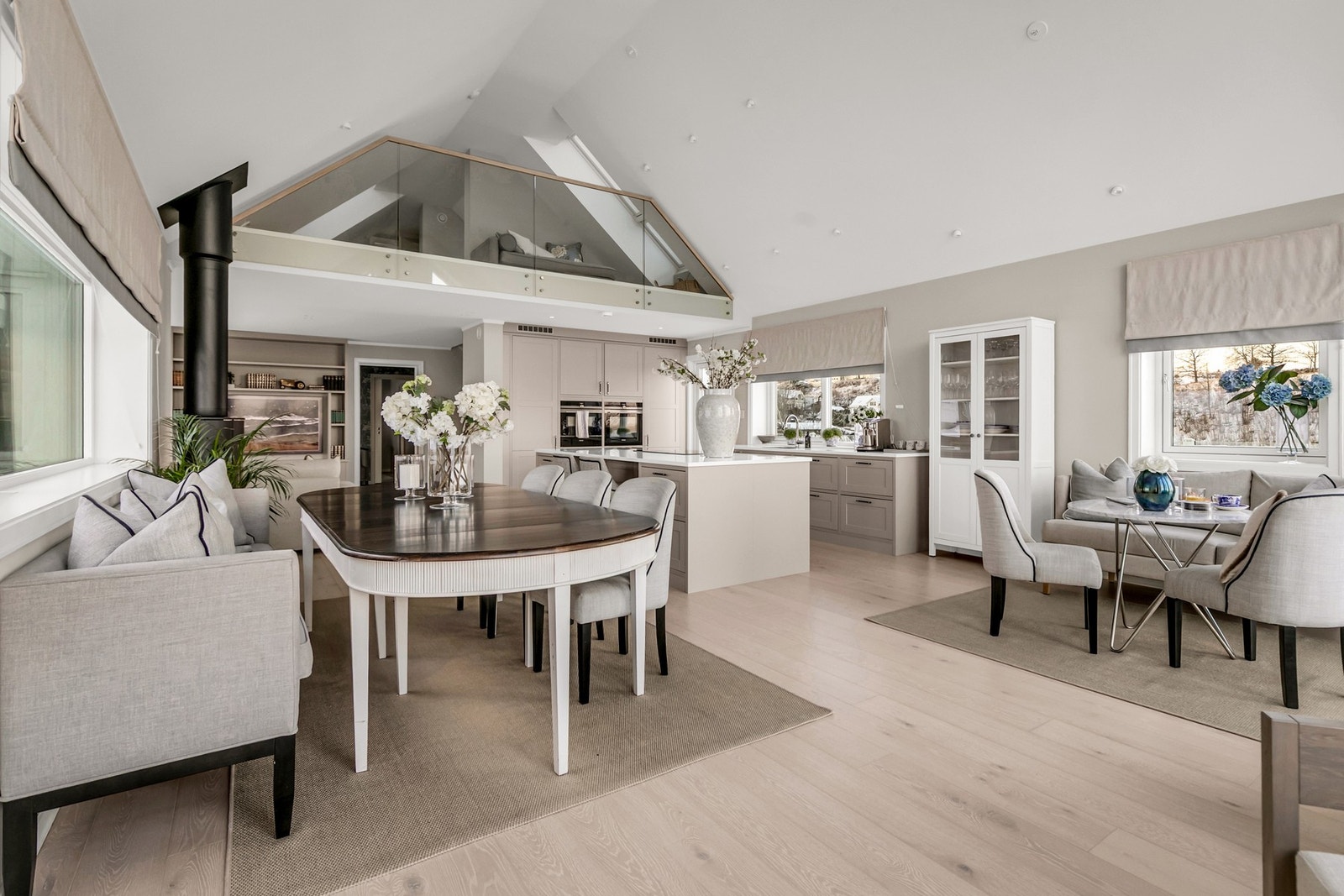 Åpen løsning mellom stue og kjøkken skaper en sosial og funksjonell sone, perfekt for både hverdagsliv og selskapelige anledninger. Galleribilde