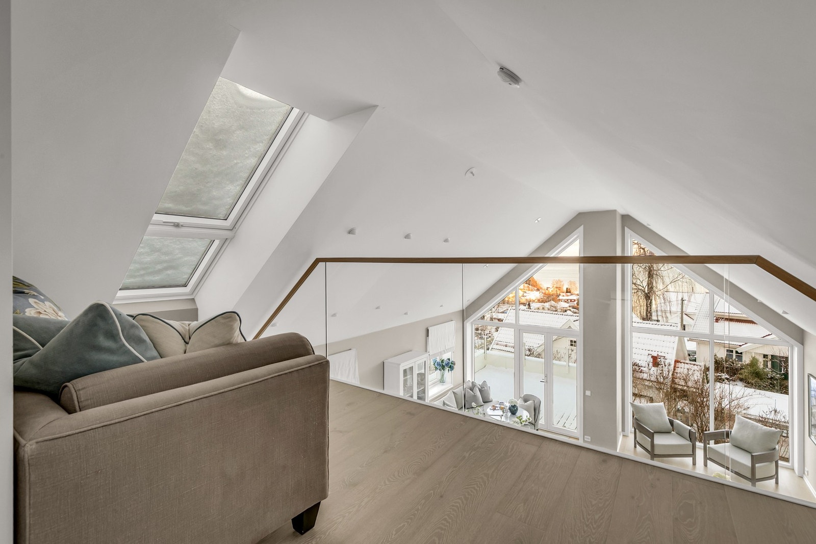 Åpen løsning med glassrekkverk gir en elegant overgang mellom etasjene og slipper lyset fritt gjennom boligen. Galleribilde