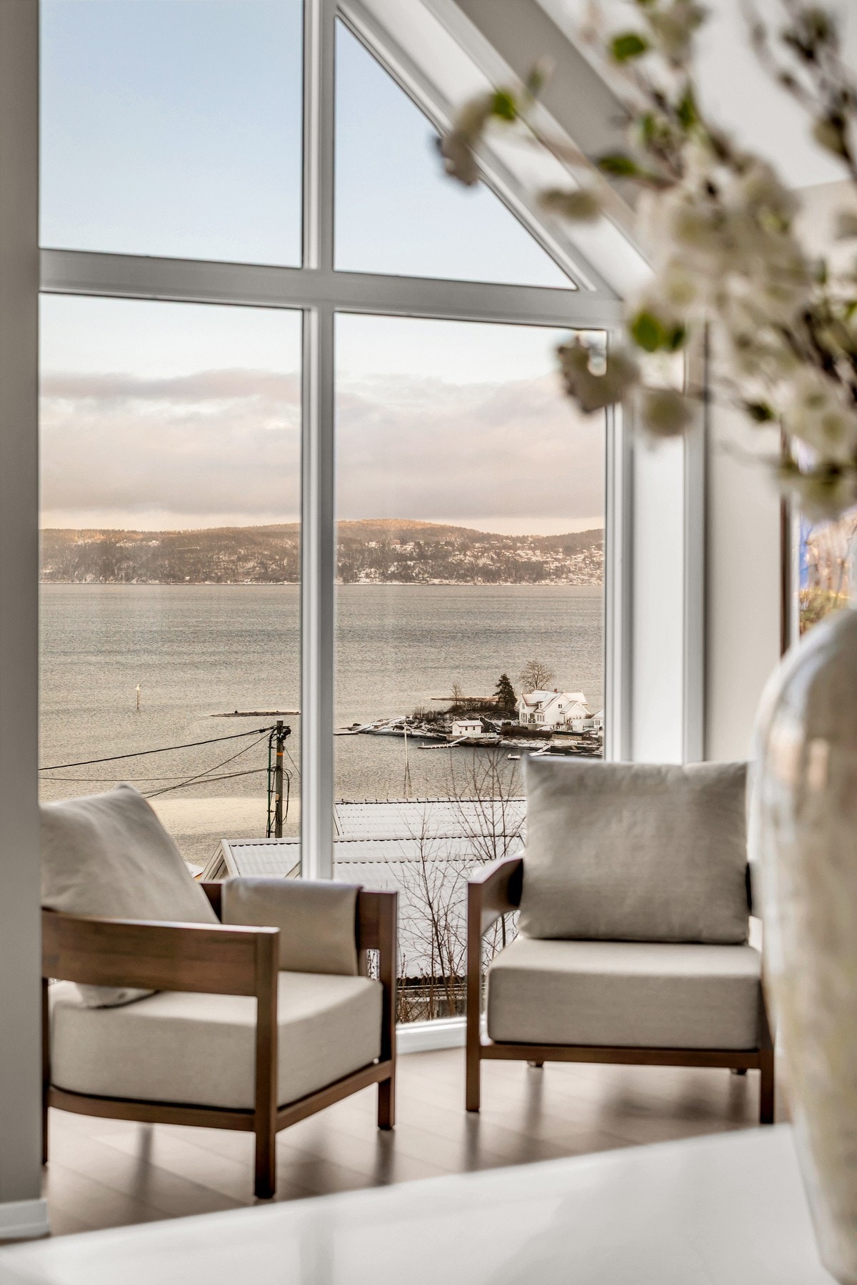 Stuen har en spektakulær sjøutsikt som blir en naturlig del av rommet. Store vinduer fra gulv til tak rammer inn landskapet og gir en unik atmosfære året rundt. Galleribilde