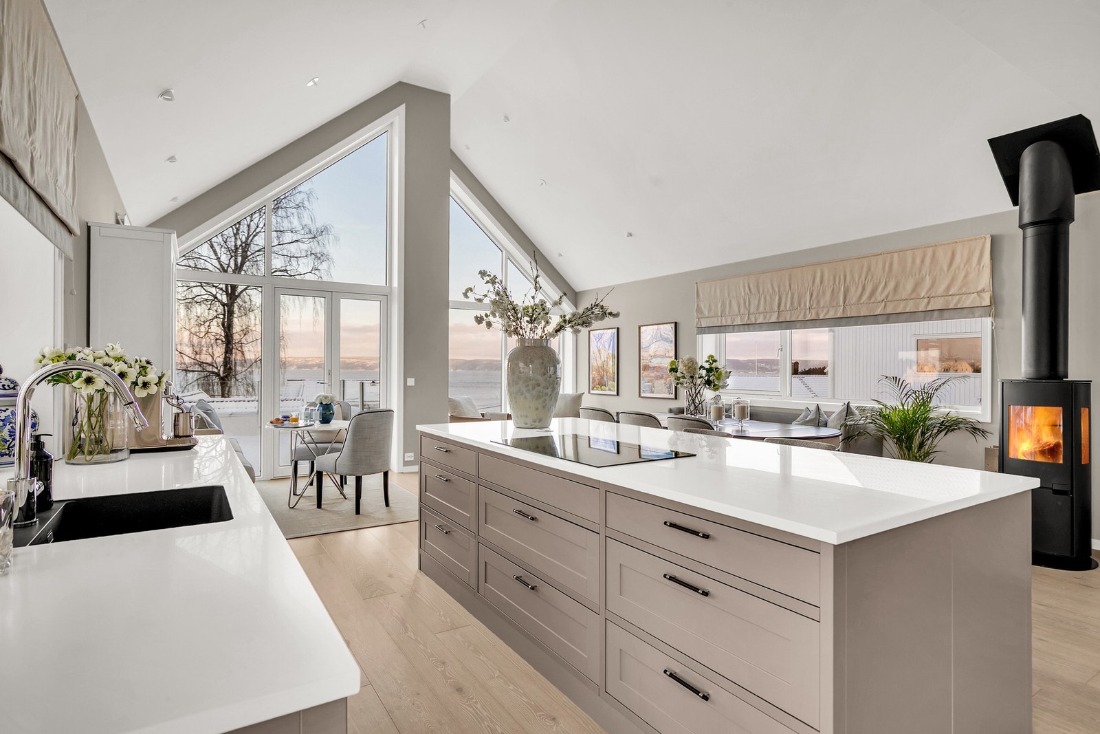 Åpen stue- og kjøkkenløsning i toppetasjen gir en imponerende romfølelse med generøs takhøyde og store vindusflater. Her slipper lyset og utsikten virkelig til. Galleribilde