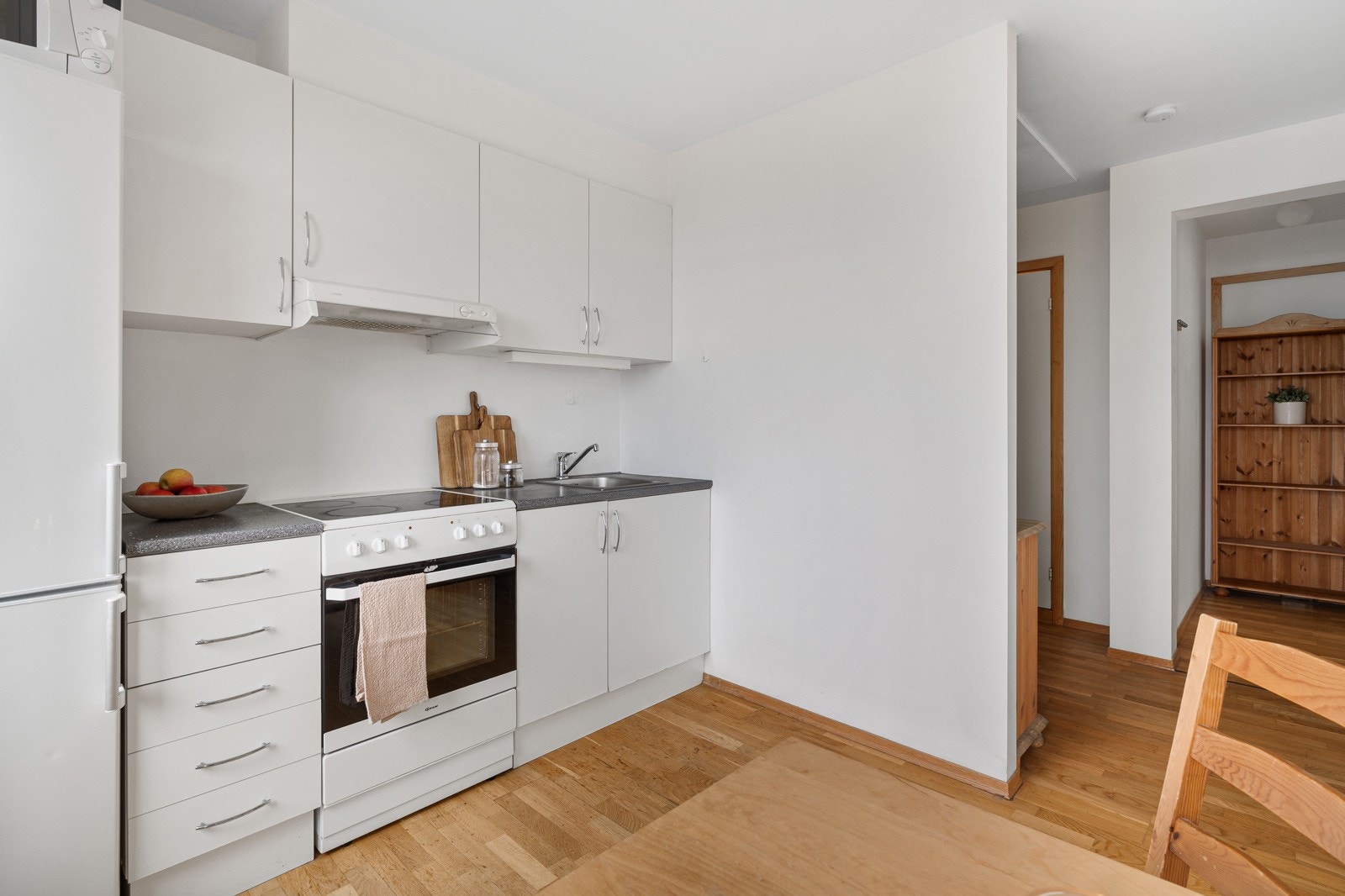 Lyst kjøkken med grei benke- og skaplass. Galleribilde