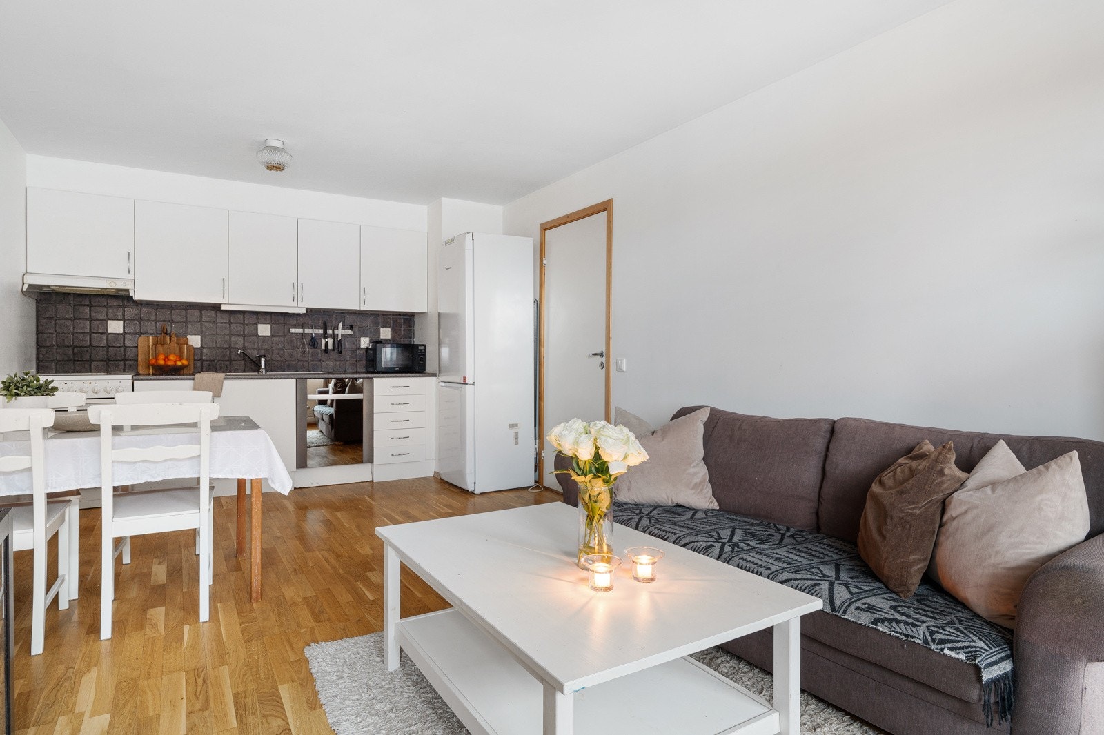 Åpen løsning mellom stue og kjøkken gir maksimal utnytelse av arealet. Her er det plass til sofa- og spisebordløsninger. Galleribilde