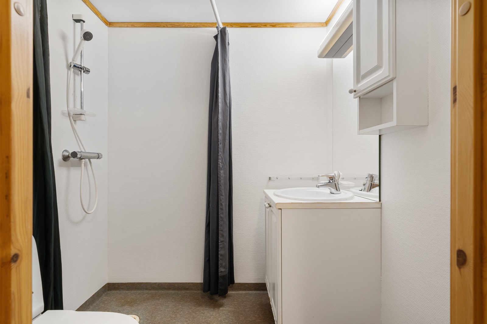 Baderommet er utstyrt med dusjarmatur, toalett og servant med under- og overskap. Galleribilde