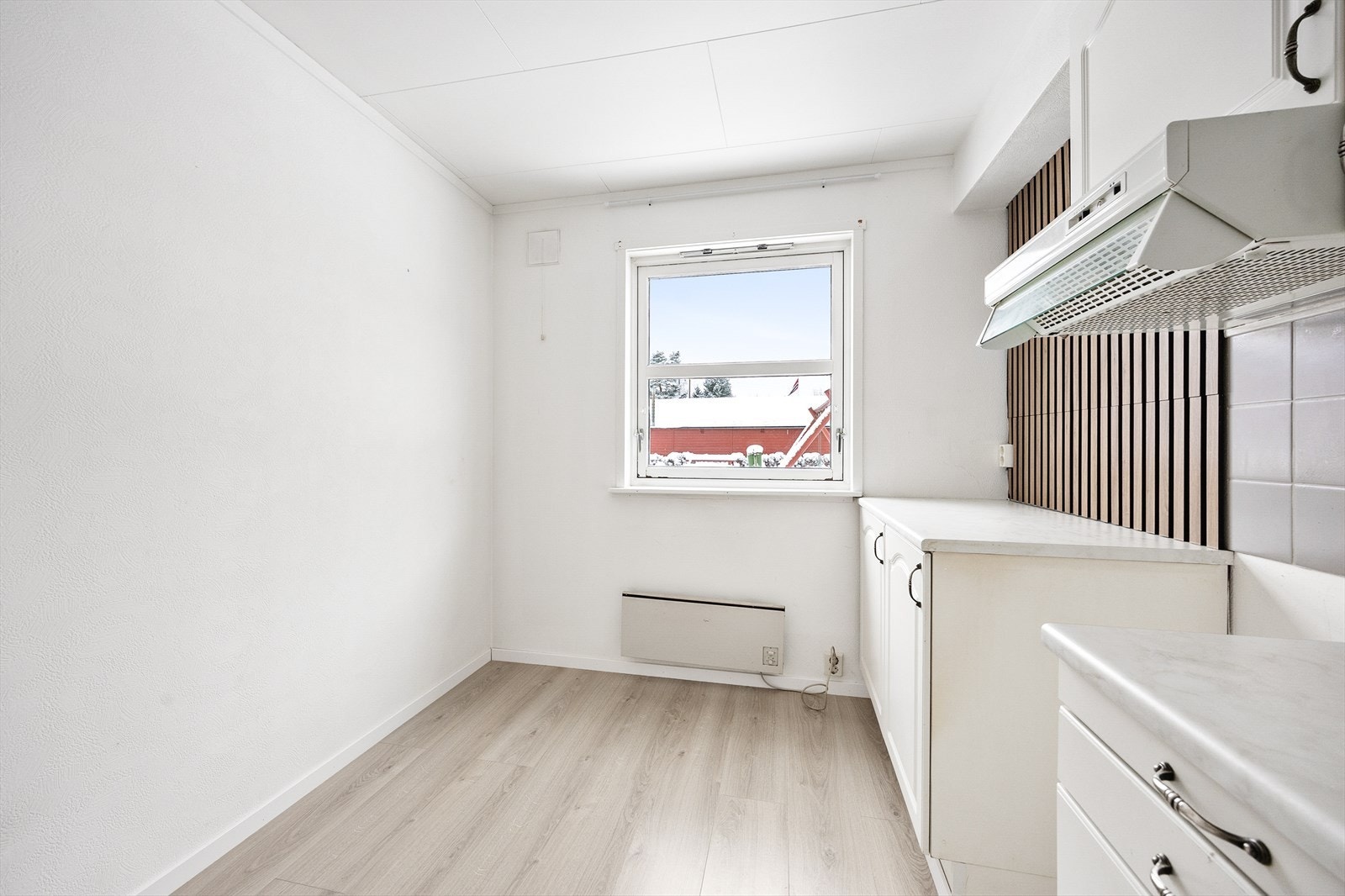 Det er plass til frokostbord på kjøkkenet, og her finnes også et nordvendt vindu med utsikt mot fellesareal Galleribilde