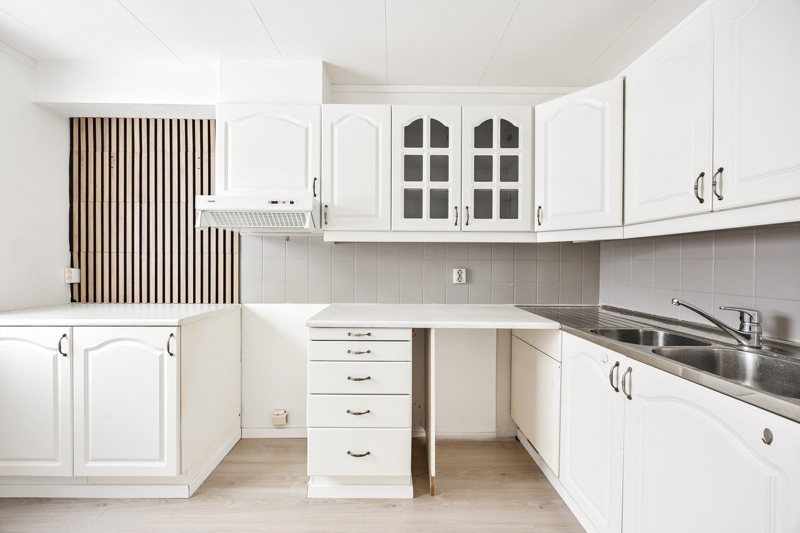 Innredningen har lyse, profilerte fronter og laminatbenkeplate med dobbel oppvaskkum. Galleribilde