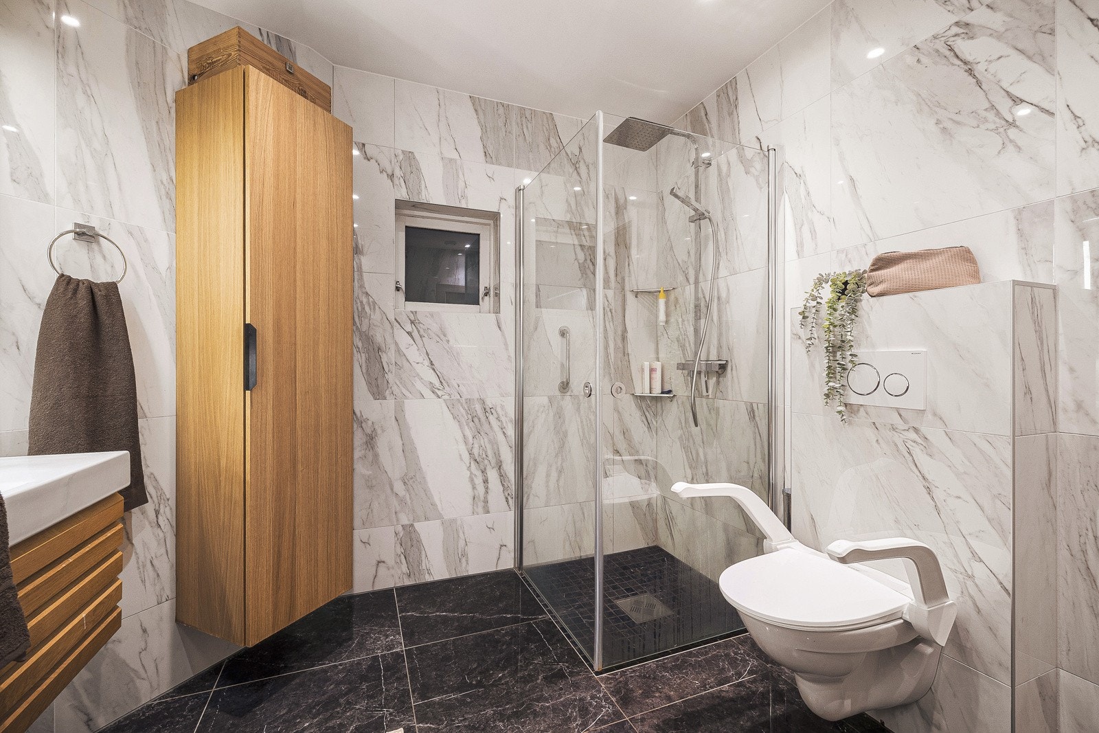 Bad i 1. etasje er innredet med baderomsinnredning med nedfelt servant, vegghengt toalett, dusjhjørne og opplegg for vaskemaskin. Galleribilde