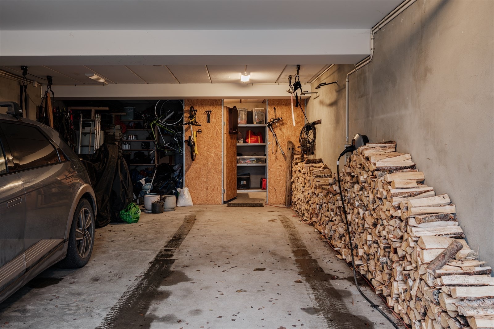 Garasjeplass med lader. Selger har fått plass til to biler etter hverandre i garasjen. Galleribilde