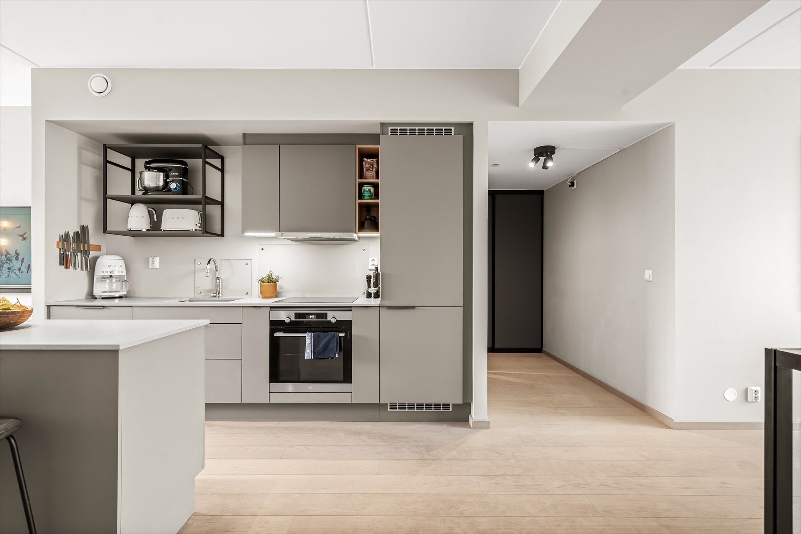 Fra entréen ledes man videre inn til boligens naturlige samlingspunkt - et moderne og sosialt kjøkken i åpen løsning mot stue. Galleribilde