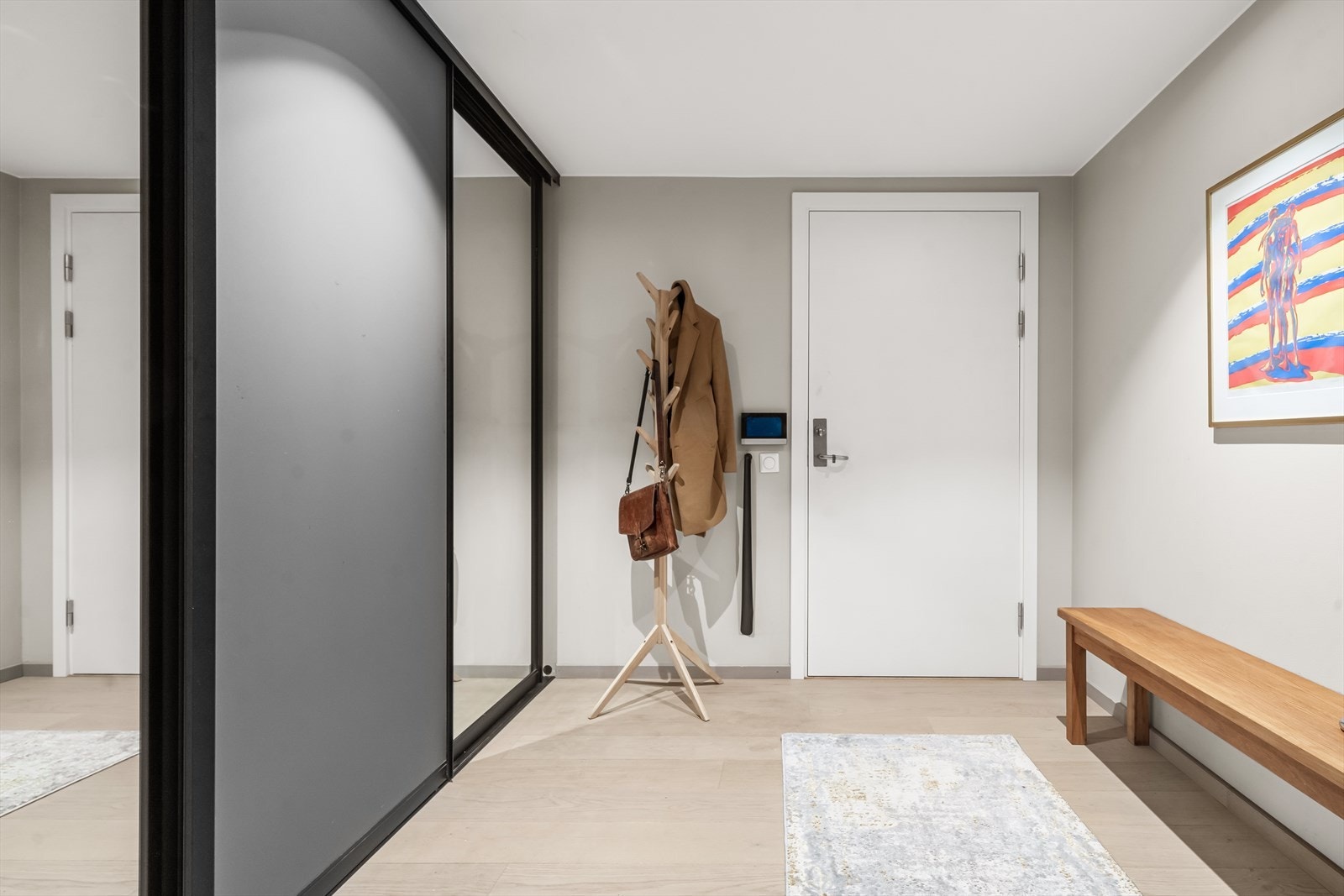 Velkommen inn i en romslig og innbydende entré som gir et svært godt førsteinntrykk av boligen. Her er det god plass til yttertøy og sko, med stor skyvedørsgarderobe med speilfronter samt plass til knaggrekke, skoskap eller annet ønsket møblement. Galleribilde