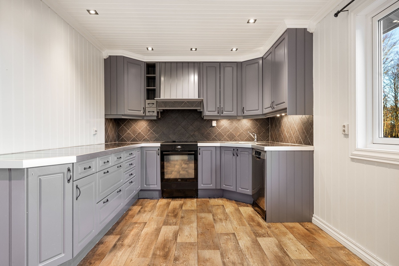 Kjøkkenet har innredning med profilerte fronter i en moderne grå nyanse. Galleribilde