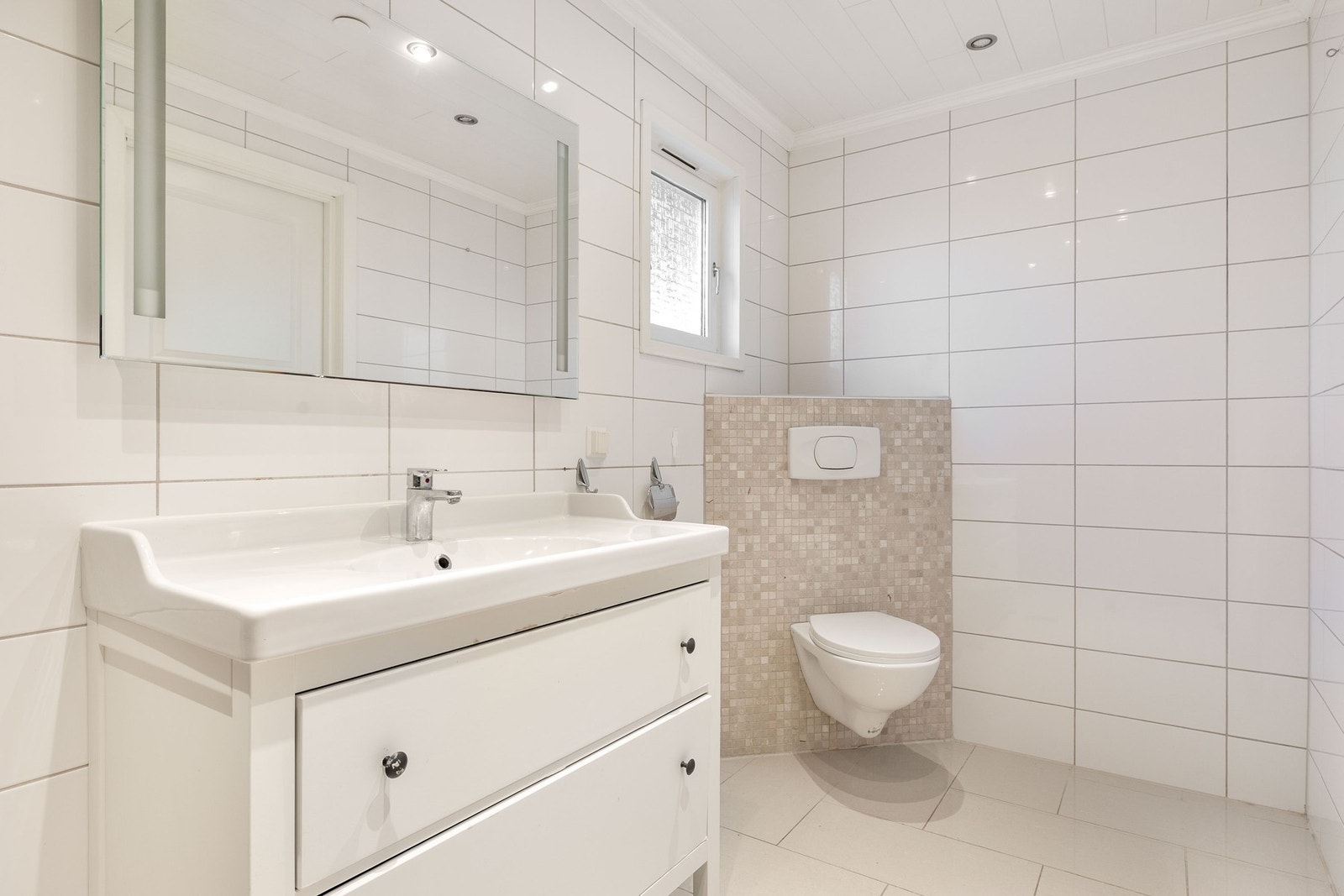 Baderommet er av god størrelse og har vegghengt toalett, opplegg for vaskemaskin, dusj, og nedfelt servant med innredning. Galleribilde