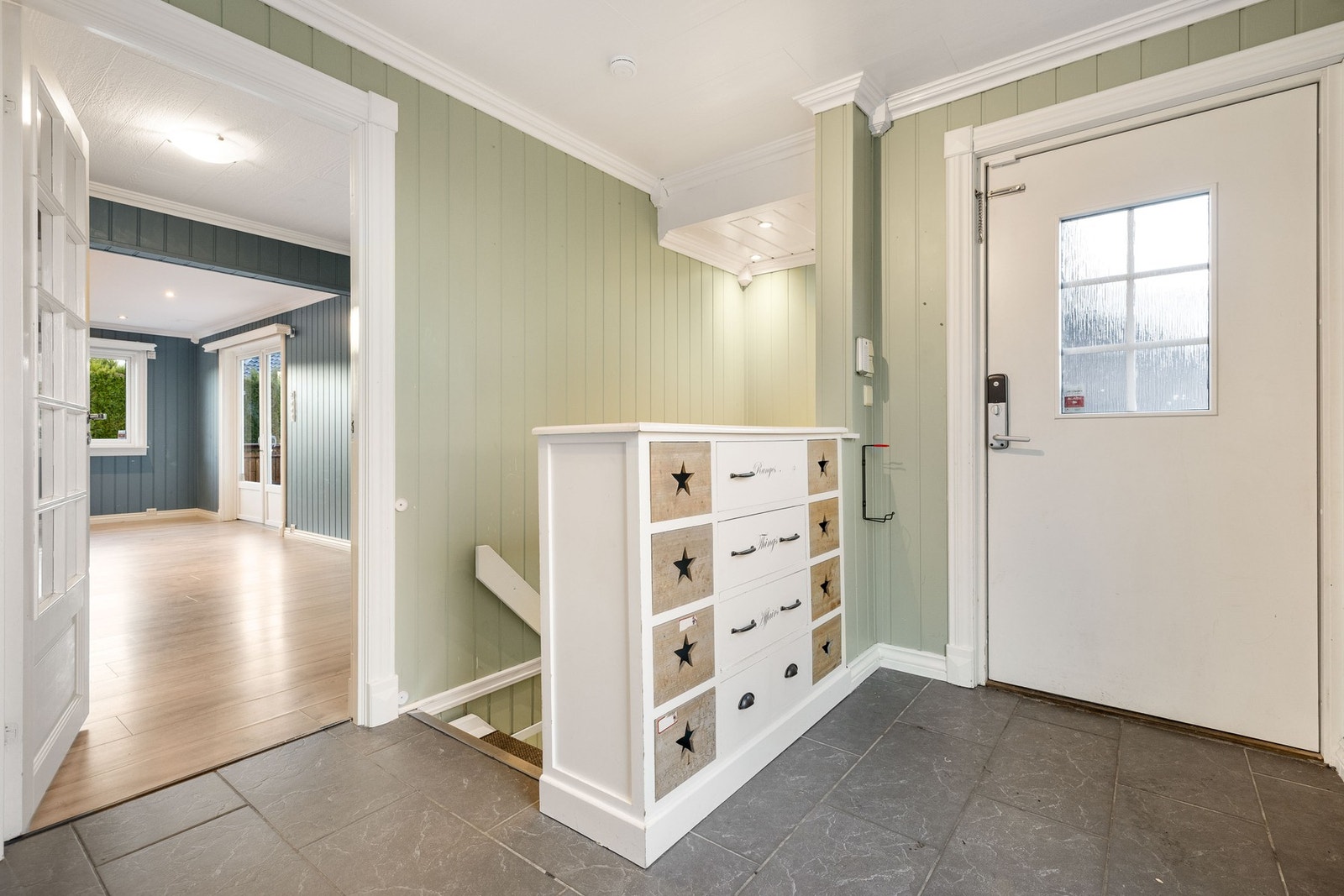 Inngangsparti med plass til organisering av familiens yttertøy og sko og trapp til boligens kjelleretasje. Galleribilde