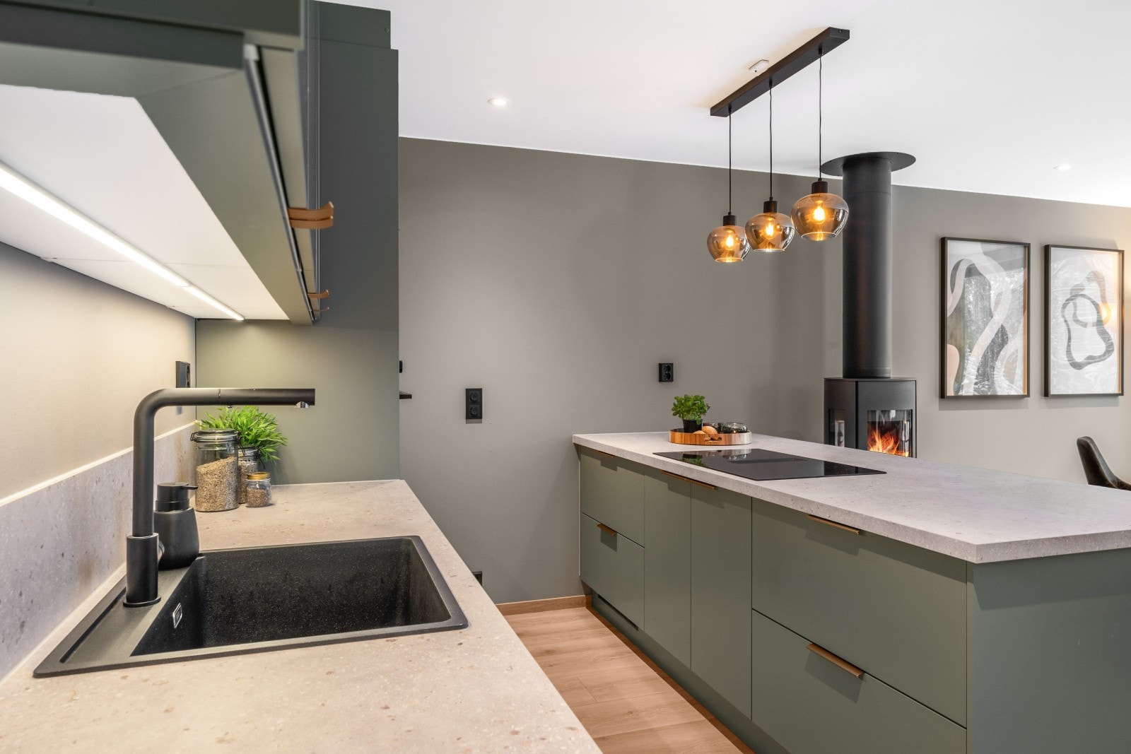 Kjøkkenet har en elegant benkeplate og delikat belysning over kjøkkenøya, som gir et stilrent uttrykk. Galleribilde