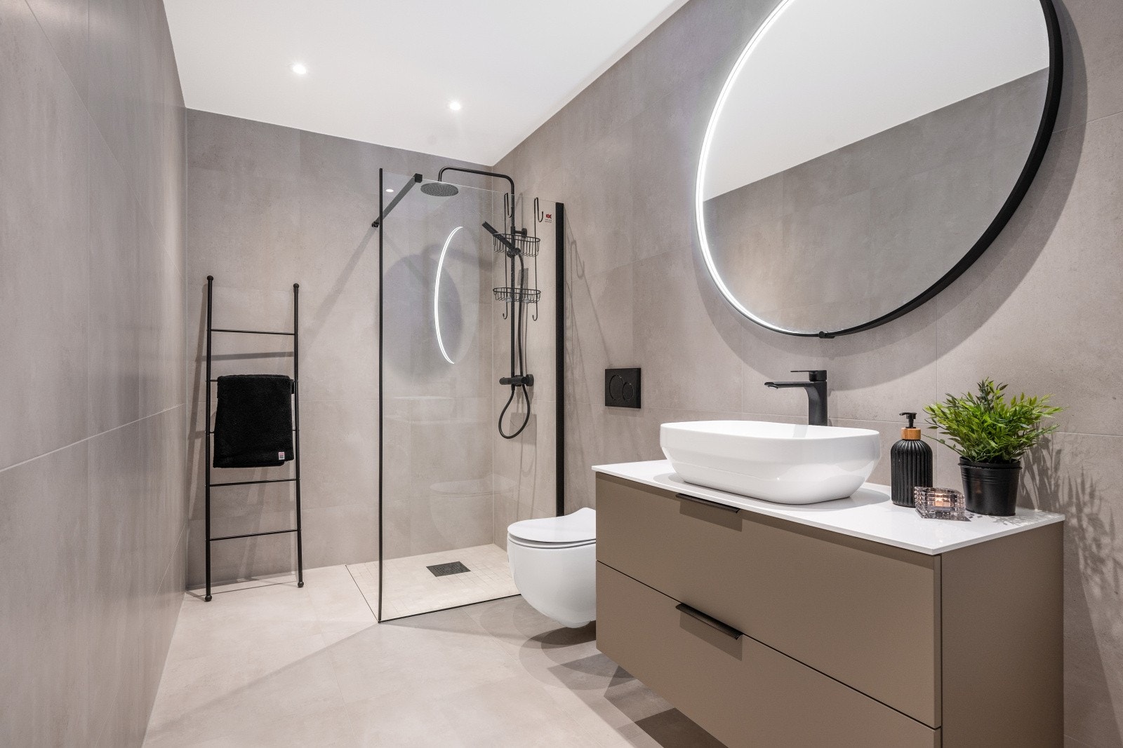 Badet har et tidløst og elegant uttrykk med flotte fliser og varmekabler i gulvet som gir ekstra komfort. Galleribilde