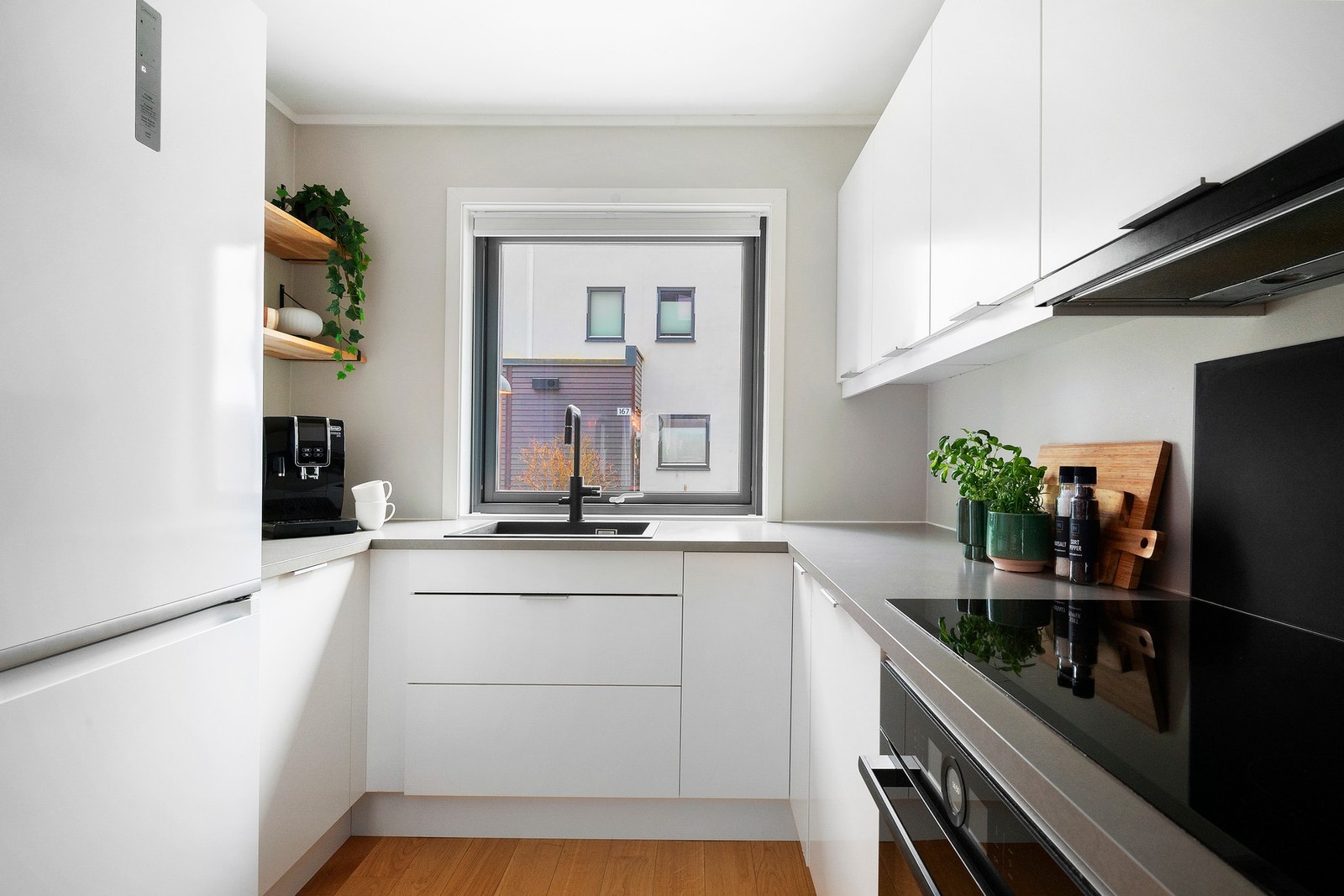 Kjøkkeninnredningen består av slette fronter, laminat benkeplate og delvis integrerte hvitevarer Galleribilde