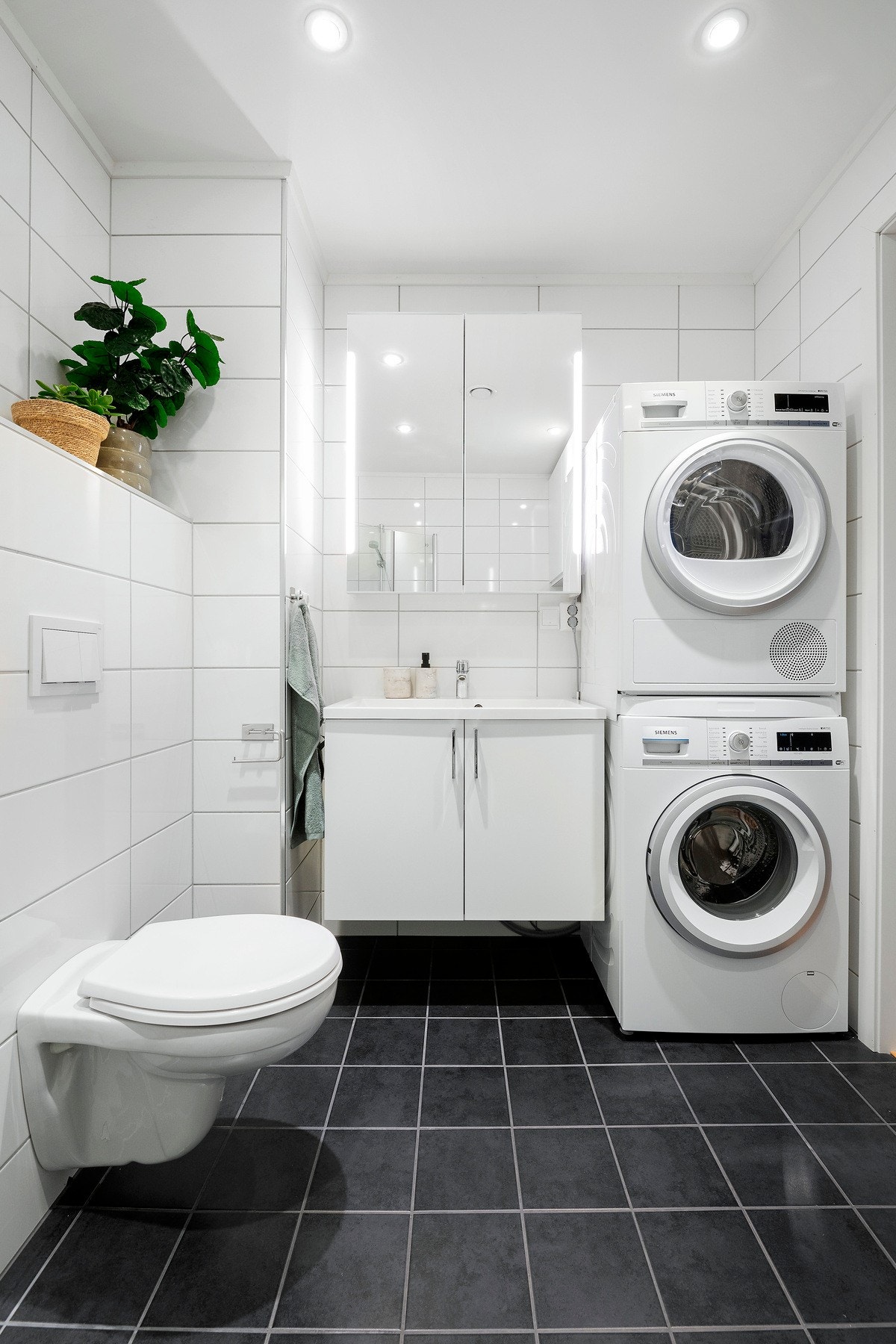 Helfliset baderom med varme i gulv, downlights i himling og opplegg for vaskemaskin og tørketrommel Galleribilde