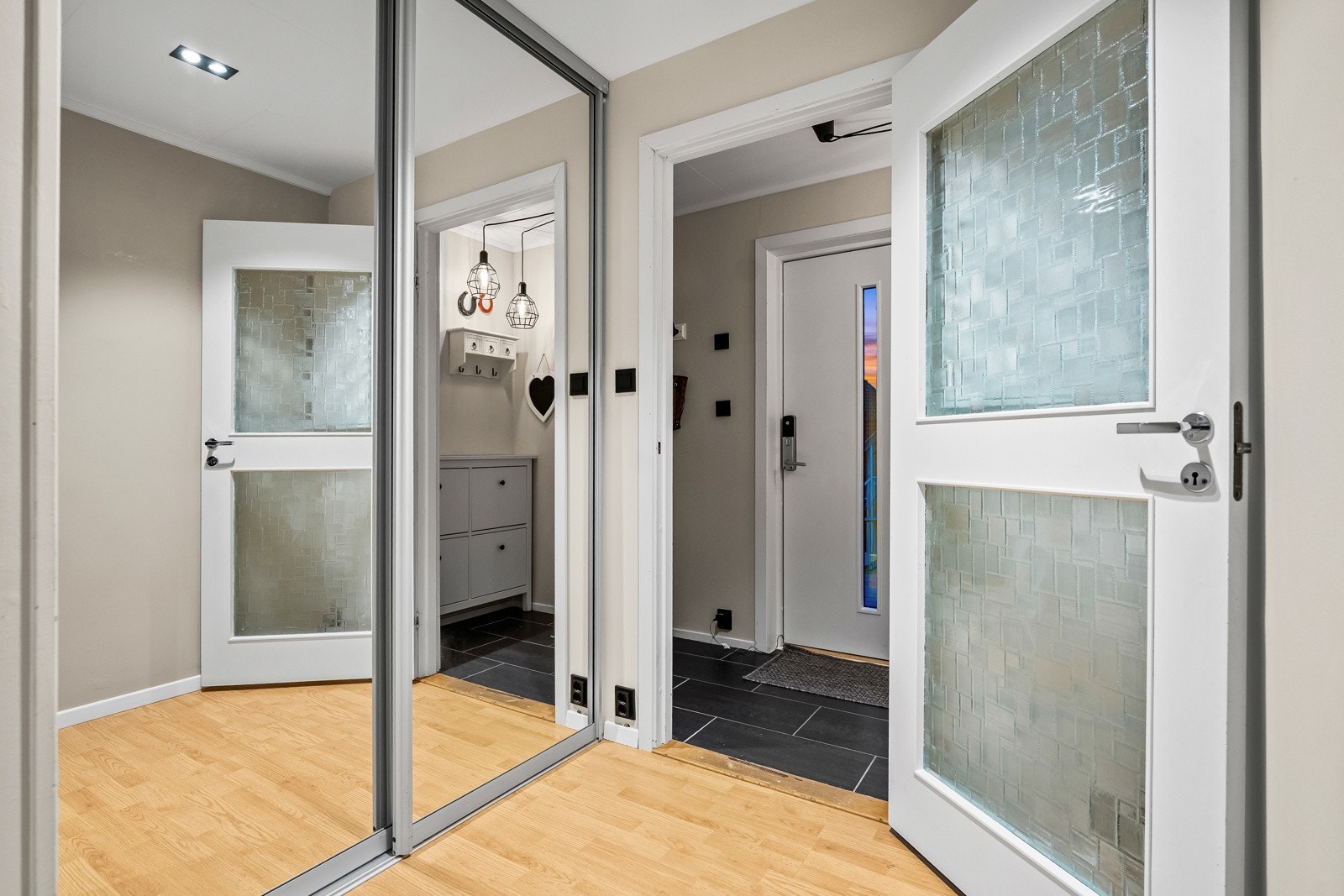 På innsiden trer man inn i en entré med flislagt gulv, som gir et praktisk og slitesterkt underlag med plass til møblement for oppbevaring av yttertøy. Galleribilde